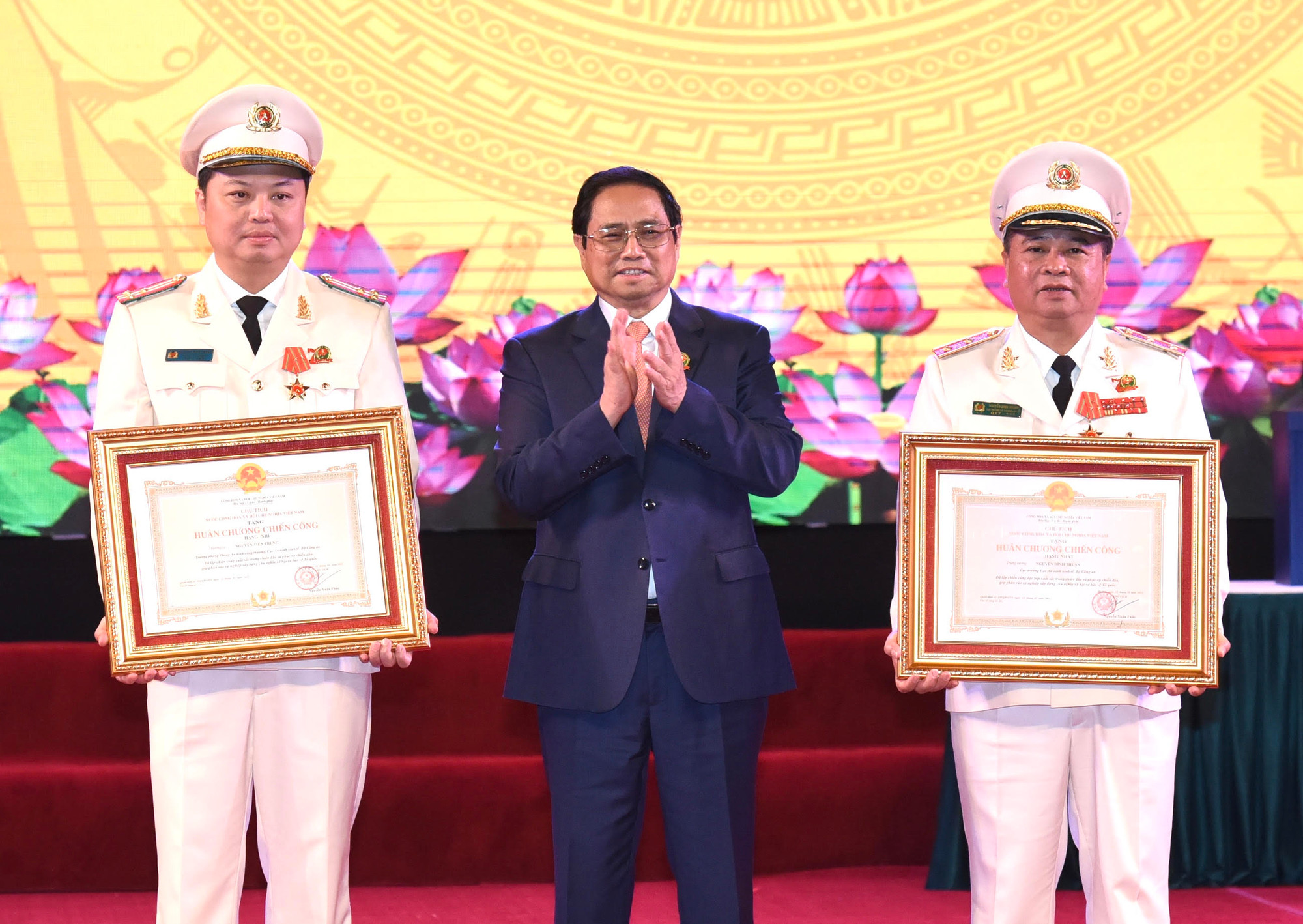 Thủ tướng Phạm Minh Chính trao Huân chương Chiến công hạng Nhất cho Trung tướng Nguyễn Đình Thuận , Cục trưởng Cục An ninh kinh tế (bên phải) và Huân chương Chiến công hạng Nhì cho Thượng tá Nguyễn Tiến Trung, Phó Cục trưởng Cục An ninh kinh tế (bên trái).