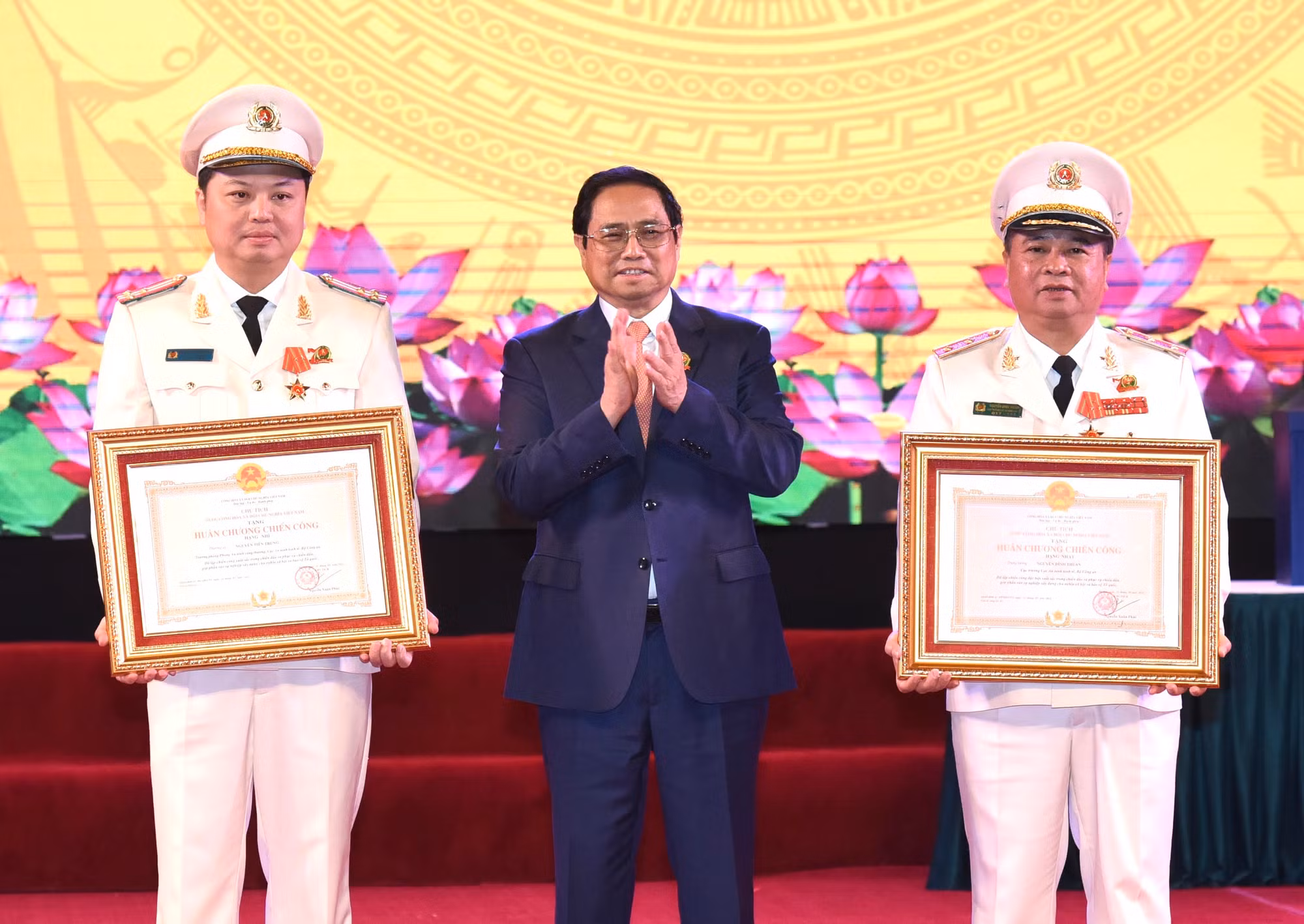 Thủ tướng Phạm Minh Chính trao Huân chương Chiến công hạng Nhất cho Trung tướng Nguyễn Đình Thuận , Cục trưởng Cục An ninh kinh tế (bên phải) và Huân chương Chiến công hạng Nhì cho Thượng tá Nguyễn Tiến Trung, Phó Cục trưởng Cục An ninh kinh tế (bên trái).