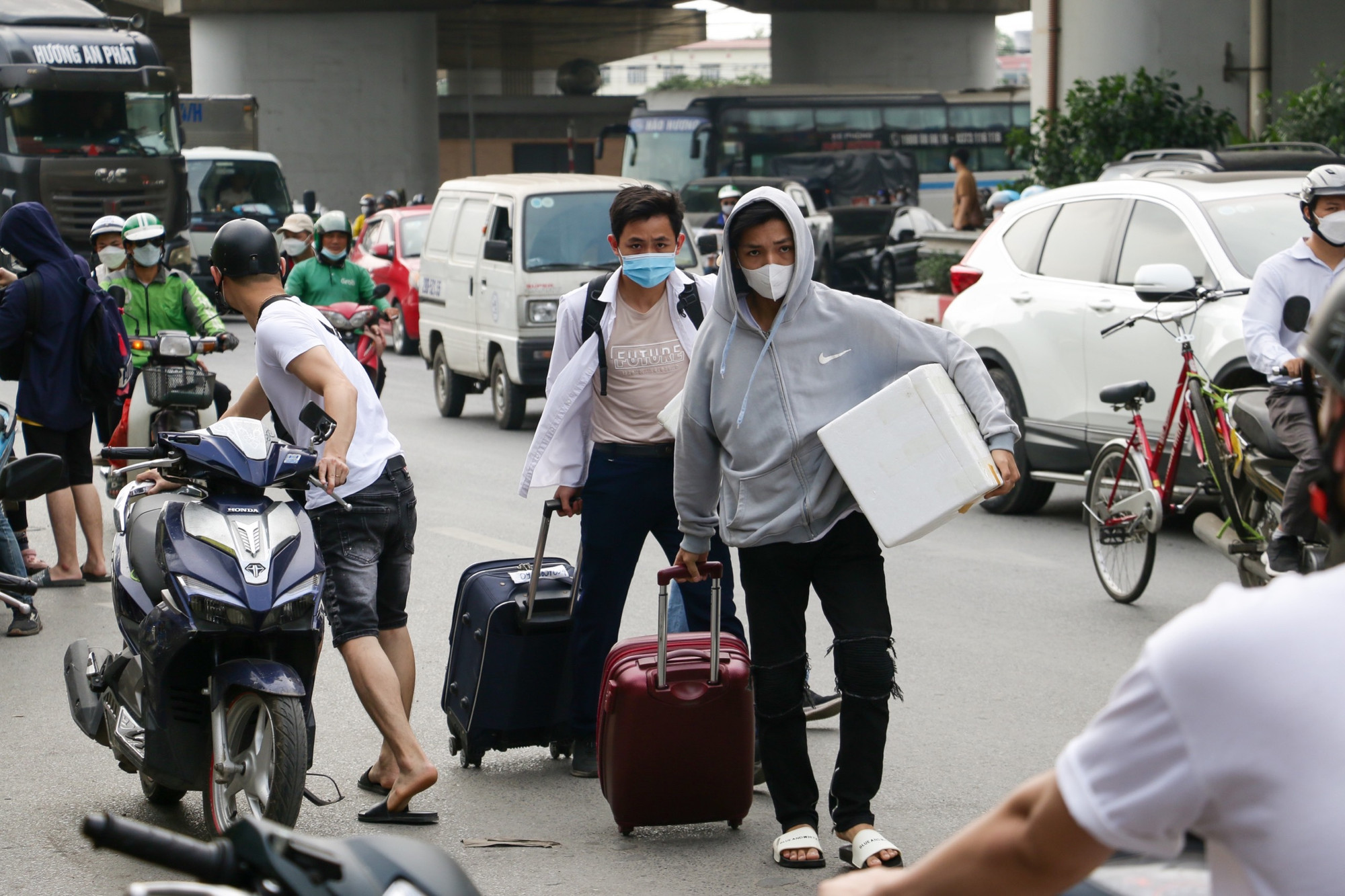 Người dân khệ nệ khiêng đồ đạc để mang lên xe khách
