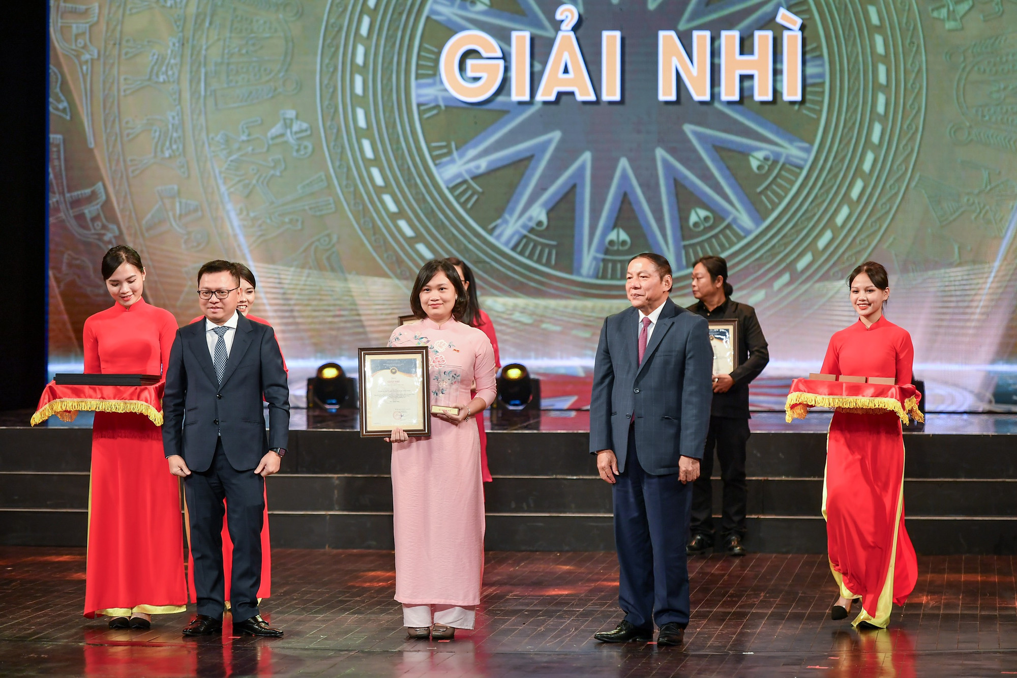 Đồng chí Lê Quốc Minh, Tổng Biên tập Báo Nhân Dân, Phó Trưởng Ban Tuyên giáo Trung ương, Chủ tịch Hội Nhà báo Việt Nam và Bộ trưởng Văn hóa, Thể thao và Du lịch Nguyễn Văn Hùng trao giải Nhì cho các tác giả, nhóm tác giả.