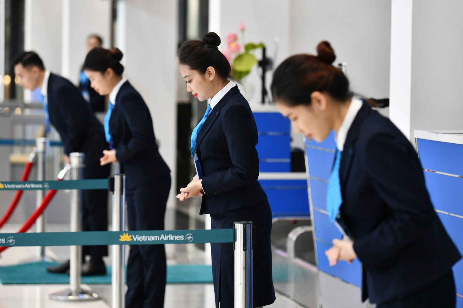 Nhân viên phục vụ mặt đất cúi chào hành khách để bắt đầu làm thủ tục chuyến bay