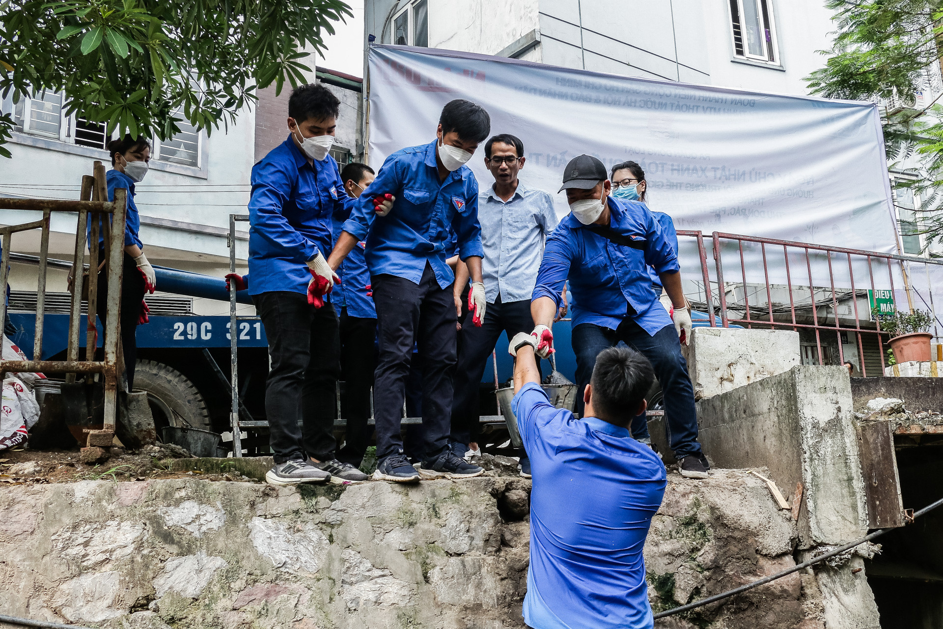 Từng xô bùn đất, phế thải được đưa lên trên. Màu áo xanh đã đầm đìa mồ hôi...