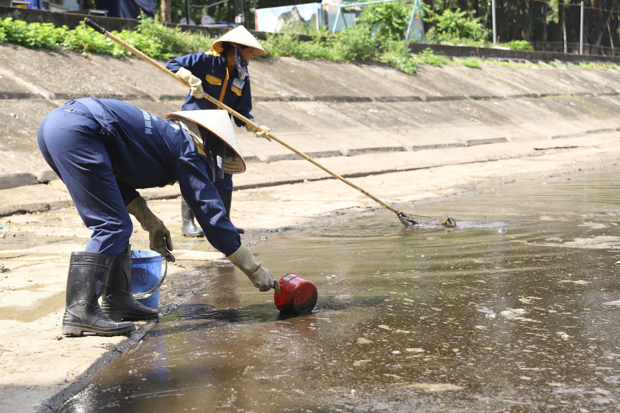 Chiều 1/10, các công nhân đã có mặt tại khu vực dầu thải xuất hiện. Do lượng dầu quá nhiều, các công nhân phải dùng gáo múc dầu thải đổ vào từng xô.