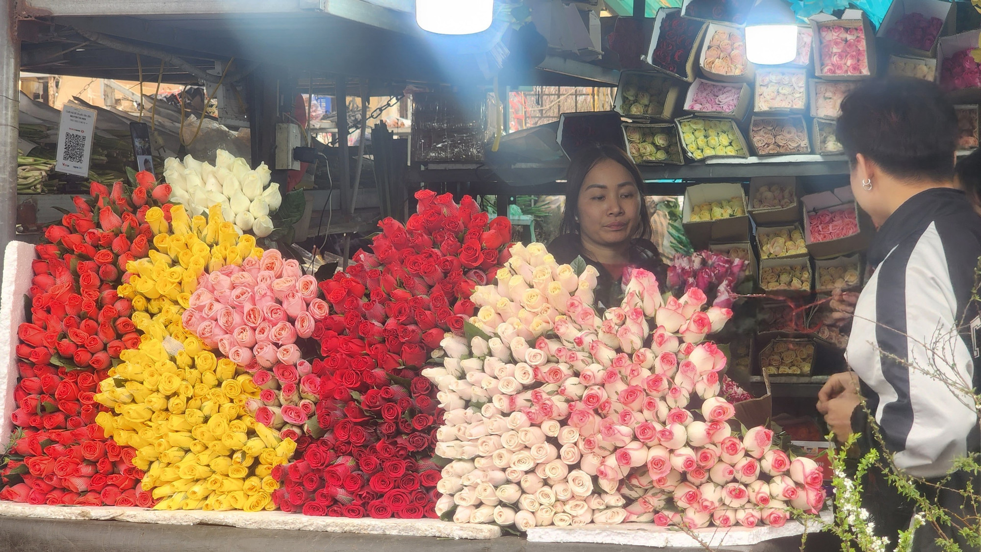 Một quầy hoa hồng với đủ loại màu sắc bên trong chợ Quảng Bá. Đây cũng là loại hoa được rất nhiều người ưa chuộng dịp Tết năm nay.