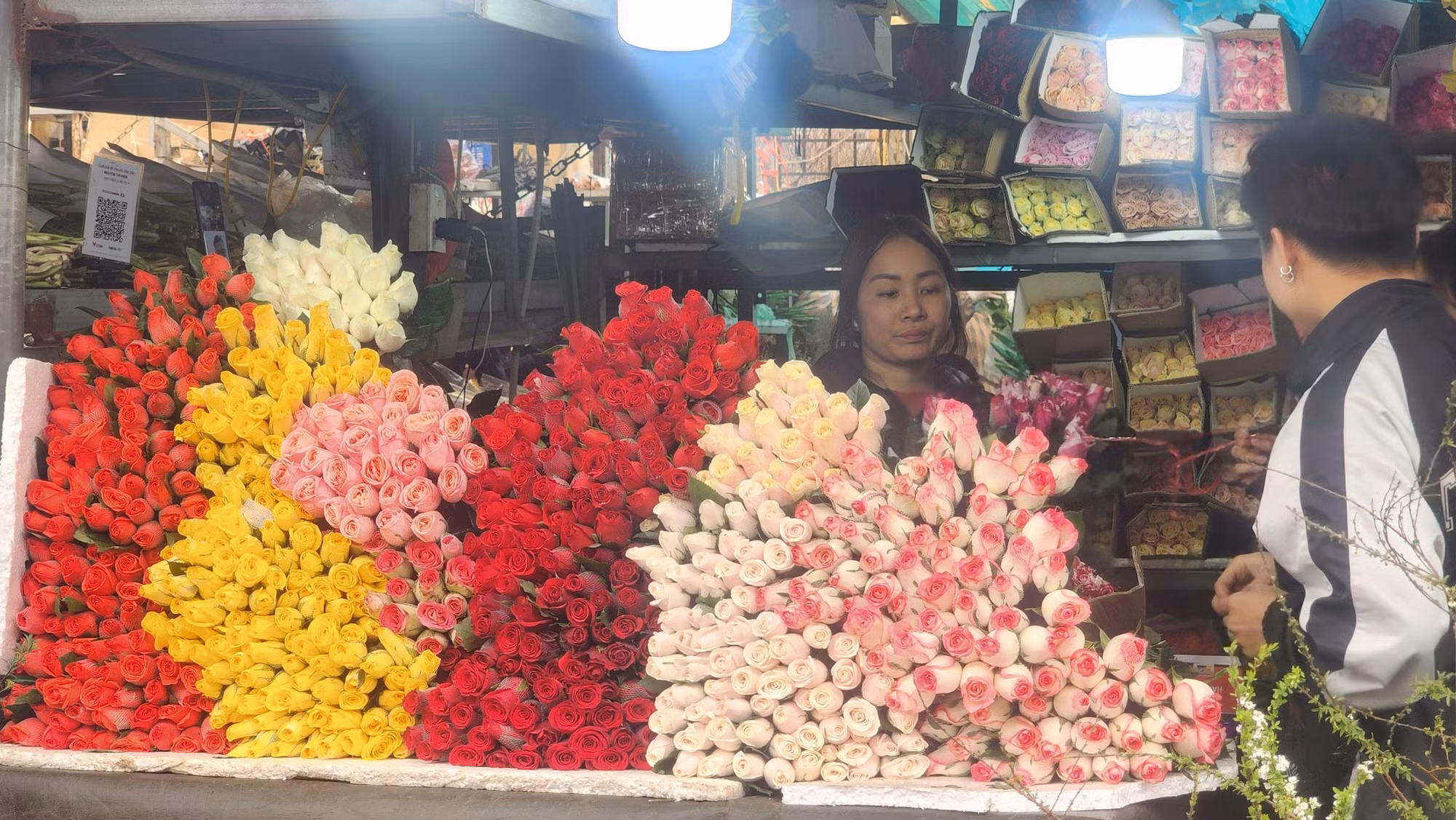 Một quầy hoa hồng với đủ loại màu sắc bên trong chợ Quảng Bá. Đây cũng là loại hoa được rất nhiều người ưa chuộng dịp Tết năm nay.