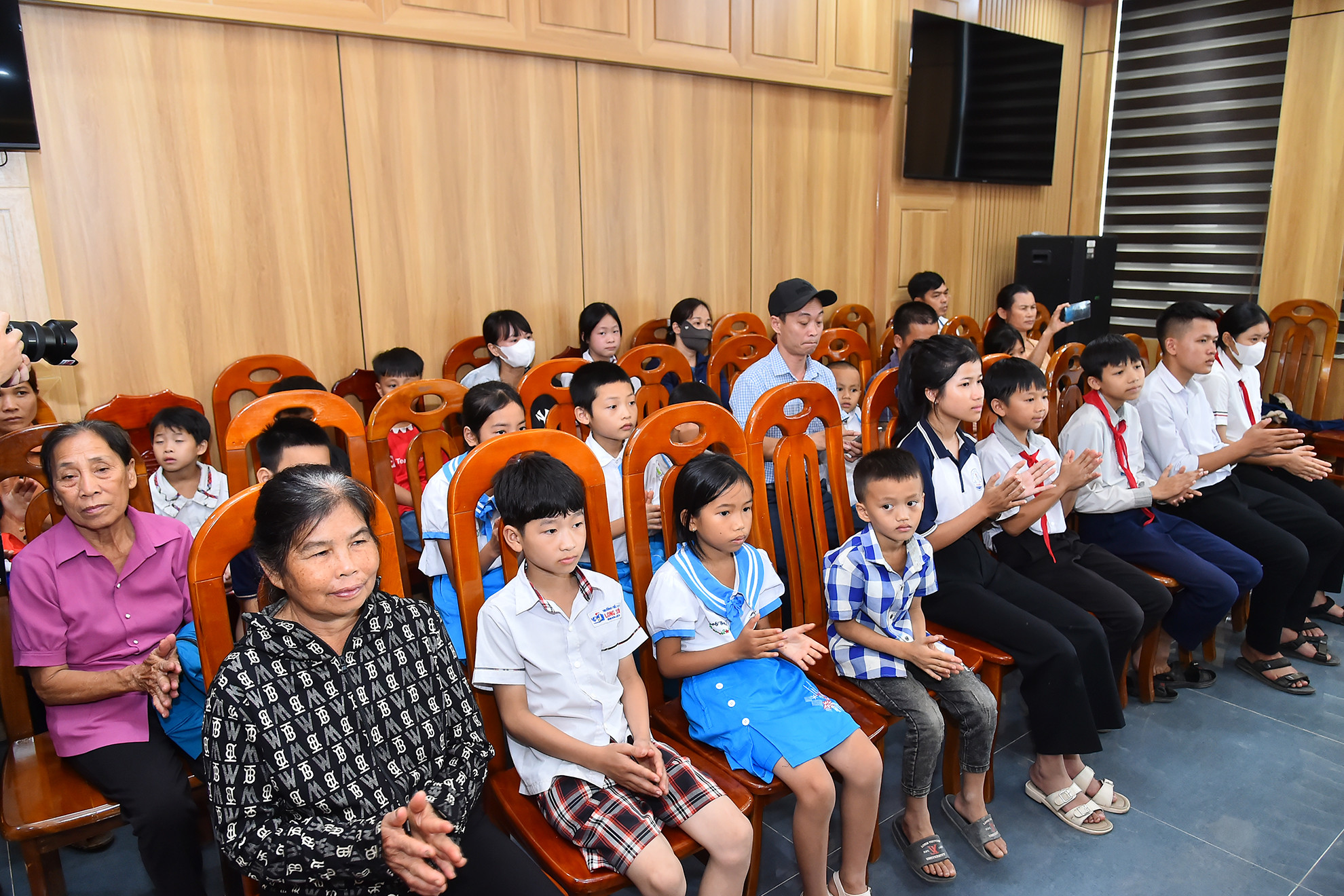 Tại buổi lễ, Chi đoàn Trung tâm Truyền hình Nhân Dân, Báo Nhân Dân và nhà tài trợ tổ chức trao 20 suất quà (mỗi suất quà trị giá 1.000.000 đồng) cho các em học sinh nghèo vượt khó năm 2024 tại huyện Anh Sơn. Trong ảnh: Các em học sinh và đại diện gia đình tham dự buổi lễ tặng quà học sinh nghèo vượt khó năm 2024 tại huyện Anh Sơn.