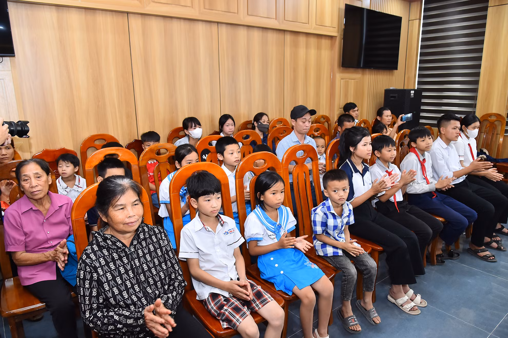 Tại buổi lễ, Chi đoàn Trung tâm Truyền hình Nhân Dân, Báo Nhân Dân và nhà tài trợ tổ chức trao 20 suất quà (mỗi suất quà trị giá 1.000.000 đồng) cho các em học sinh nghèo vượt khó năm 2024 tại huyện Anh Sơn. Trong ảnh: Các em học sinh và đại diện gia đình tham dự buổi lễ tặng quà học sinh nghèo vượt khó năm 2024 tại huyện Anh Sơn.