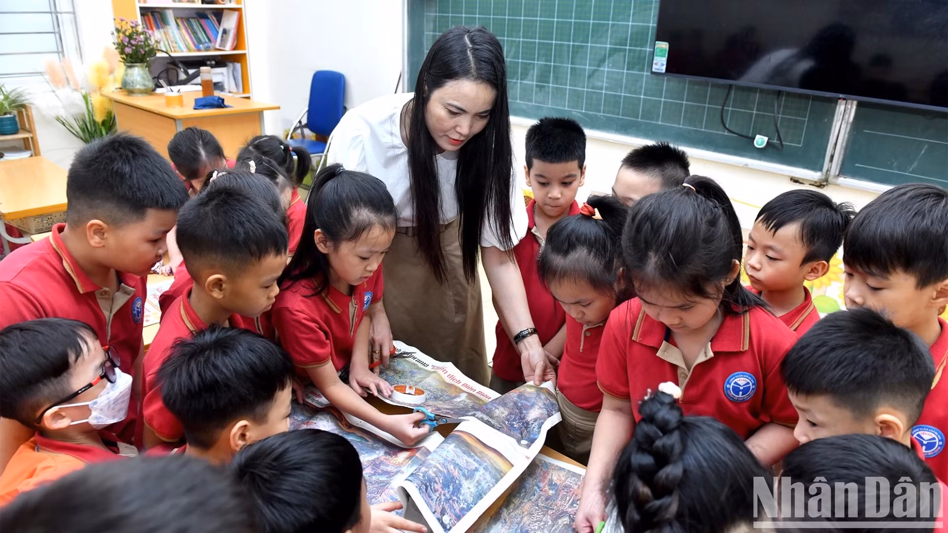 Cô giáo Nguyễn Thu Hòa hướng dẫn các cháu học sinh cắt dán bức tranh panorama “Chiến dịch Điện Biên Phủ”.