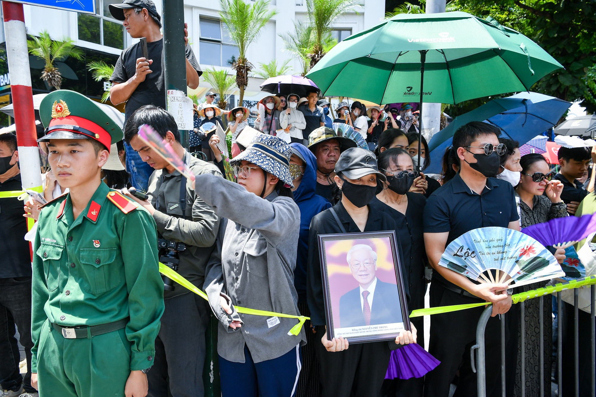 Người dân mang theo di ảnh của Tổng Bí thư Nguyễn Phú Trọng để bày tỏ niềm thương tiếc sâu sắc với nhà lãnh đạo xuất sắc của đất nước trong giờ phút tiễn biệt. (Ảnh: THÀNH ĐẠT)