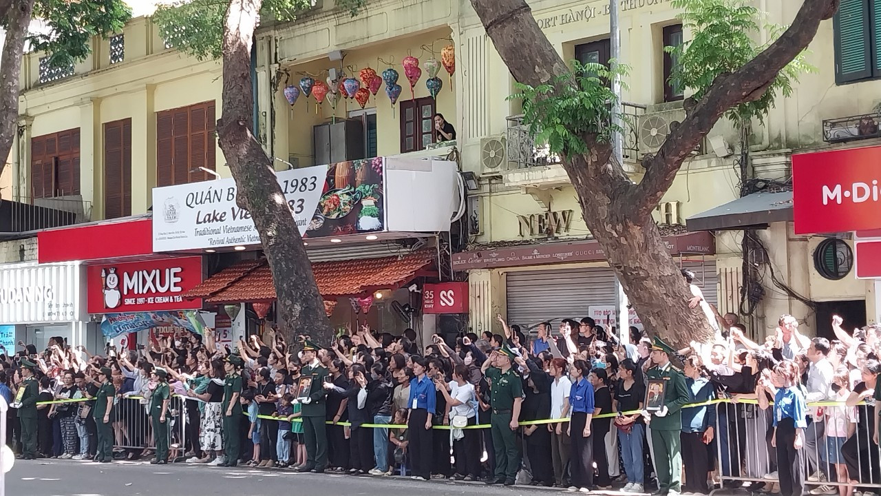 Người dân đứng ngay ngắn trên phố Hàng Khay chờ đoàn xe chở linh cữu của Tổng Bí thư Nguyễn Phú Trọng. (Ảnh: THANH NGA)