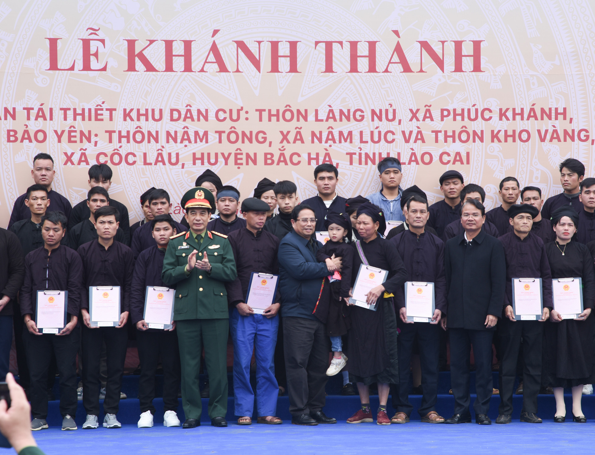 Thủ tướng Phạm Minh Chính và lãnh đạo địa phương trao chứng nhận quyền sử dụng đất tại nơi ở mới cho các gia đình thôn Làng Nủ.