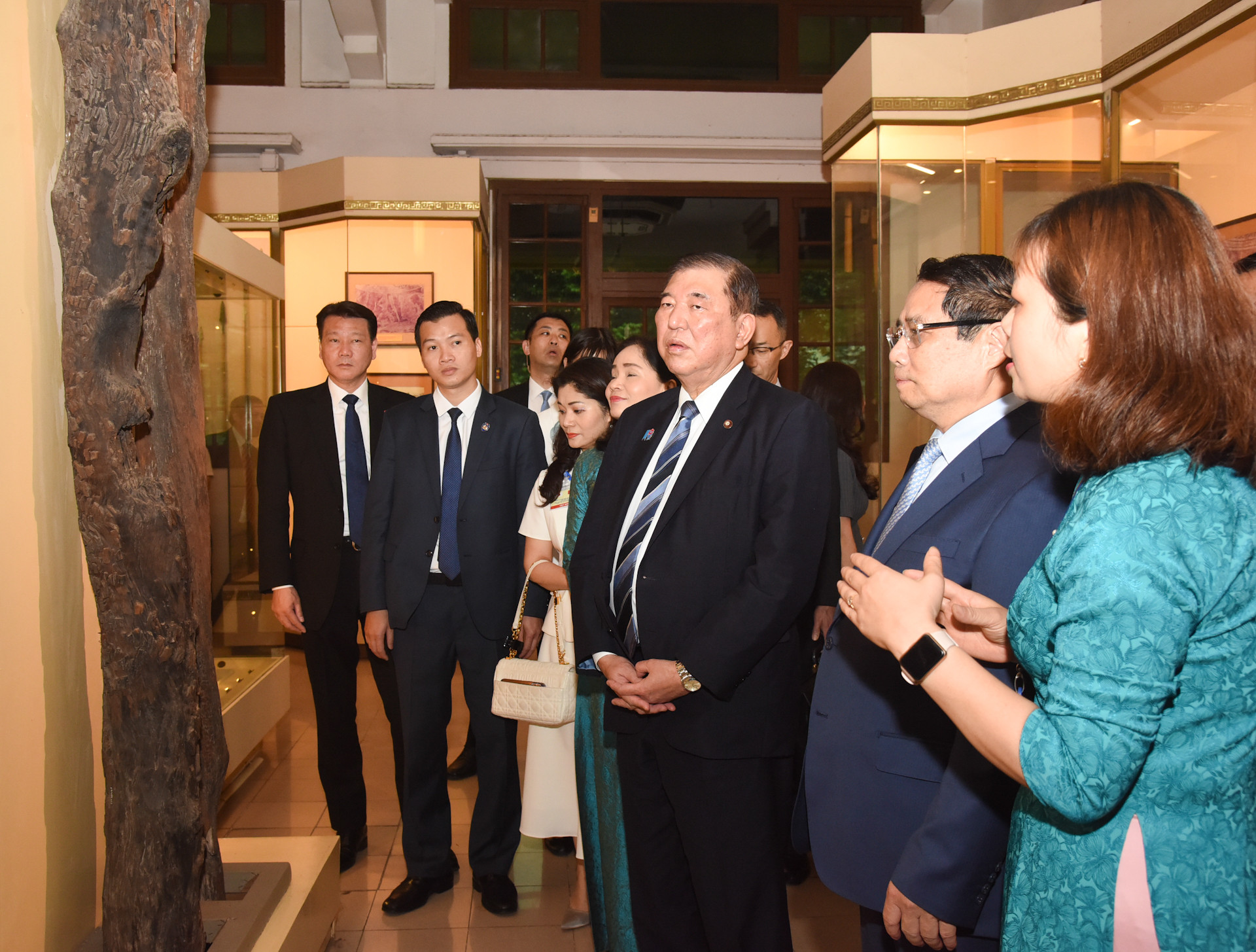 Cán bộ, công nhân viên Bảo tàng Lịch sử quốc gia giới thiệu với hai Thủ tướng và Phu nhân về các hiện vật trong bảo tàng.