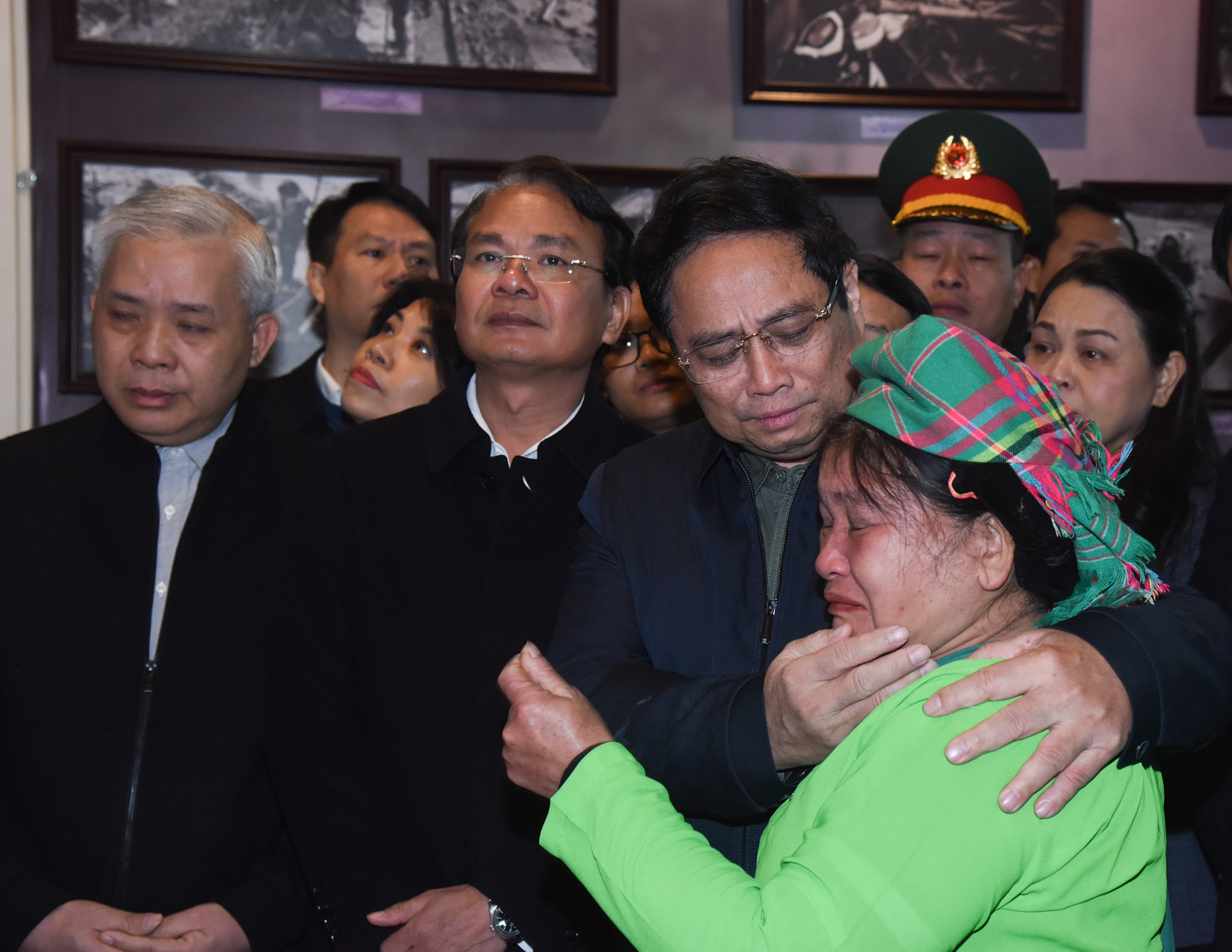 Thủ tướng Phạm Minh Chính chia sẻ với mất mát của gia đình bà Hoàng Thị Sởi tại phòng trưng bày ảnh, hiện vật về trận lũ quét tại Nhà văn hóa thôn Làng Nủ.