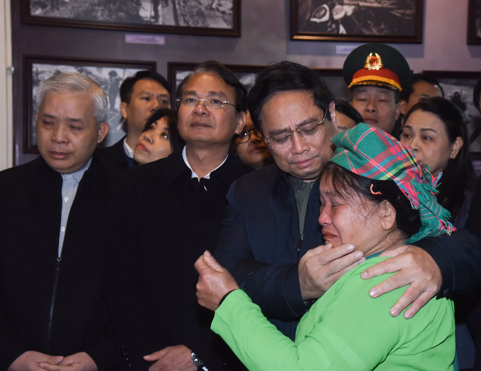 Thủ tướng Phạm Minh Chính chia sẻ với mất mát của gia đình bà Hoàng Thị Sởi tại phòng trưng bày ảnh, hiện vật về trận lũ quét tại Nhà văn hóa thôn Làng Nủ.