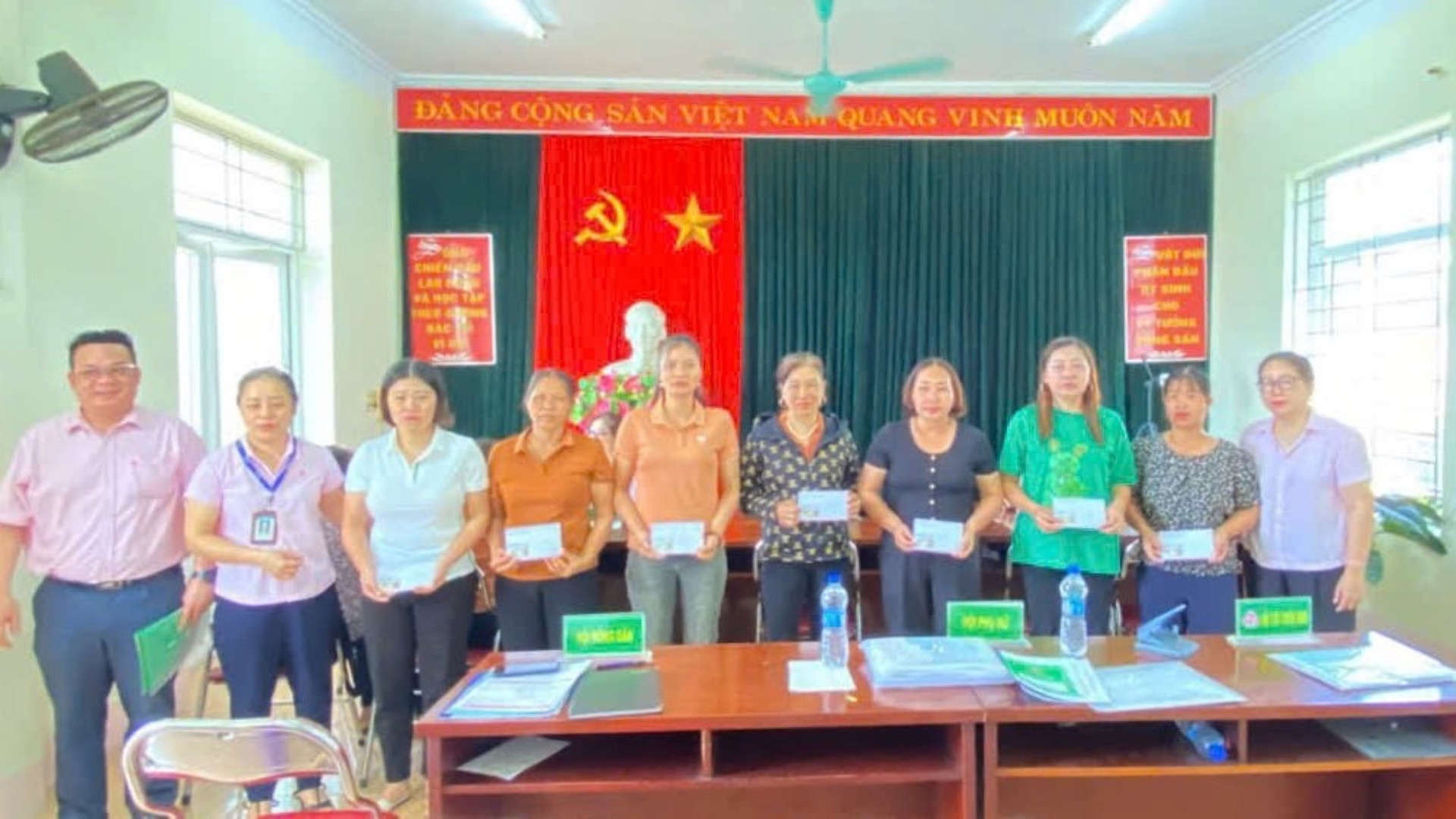 Các cán bộ tín dụng động viên, chia sẻ với các Tổ trưởng Tổ tiết kiệm và vay vốn bị thiệt hại do bão lũ tại phiên giao dịch bù vừa qua tại Yên Bái.