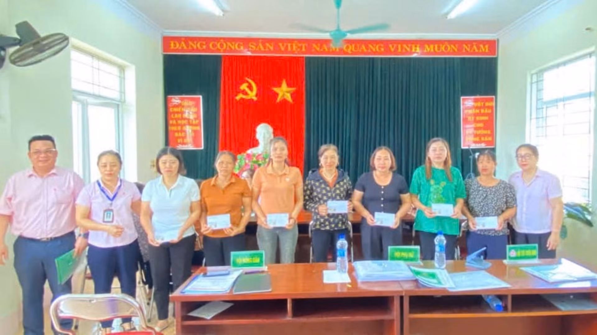 Các cán bộ tín dụng động viên, chia sẻ với các Tổ trưởng Tổ tiết kiệm và vay vốn bị thiệt hại do bão lũ tại phiên giao dịch bù vừa qua tại Yên Bái.