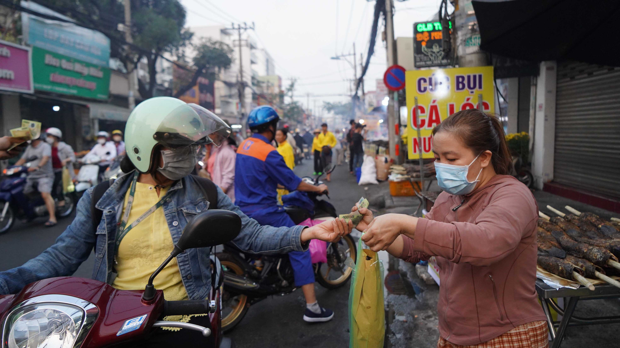 Người dân chen chật kín đường để chờ mua cá lóc nướng.