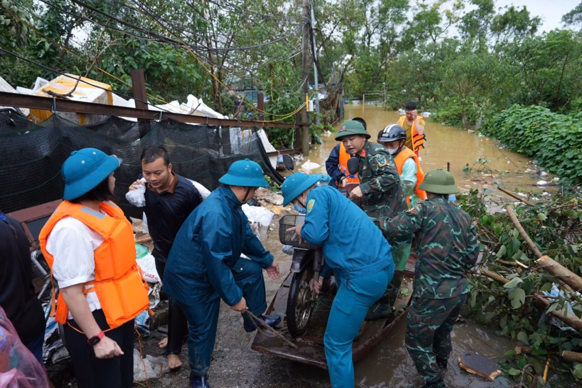 Lực lượng chức năng của quận Tây Hồ giúp di chuyển đồ đạc của người dân ra khỏi khu vực bãi giữa sông Hồng.
