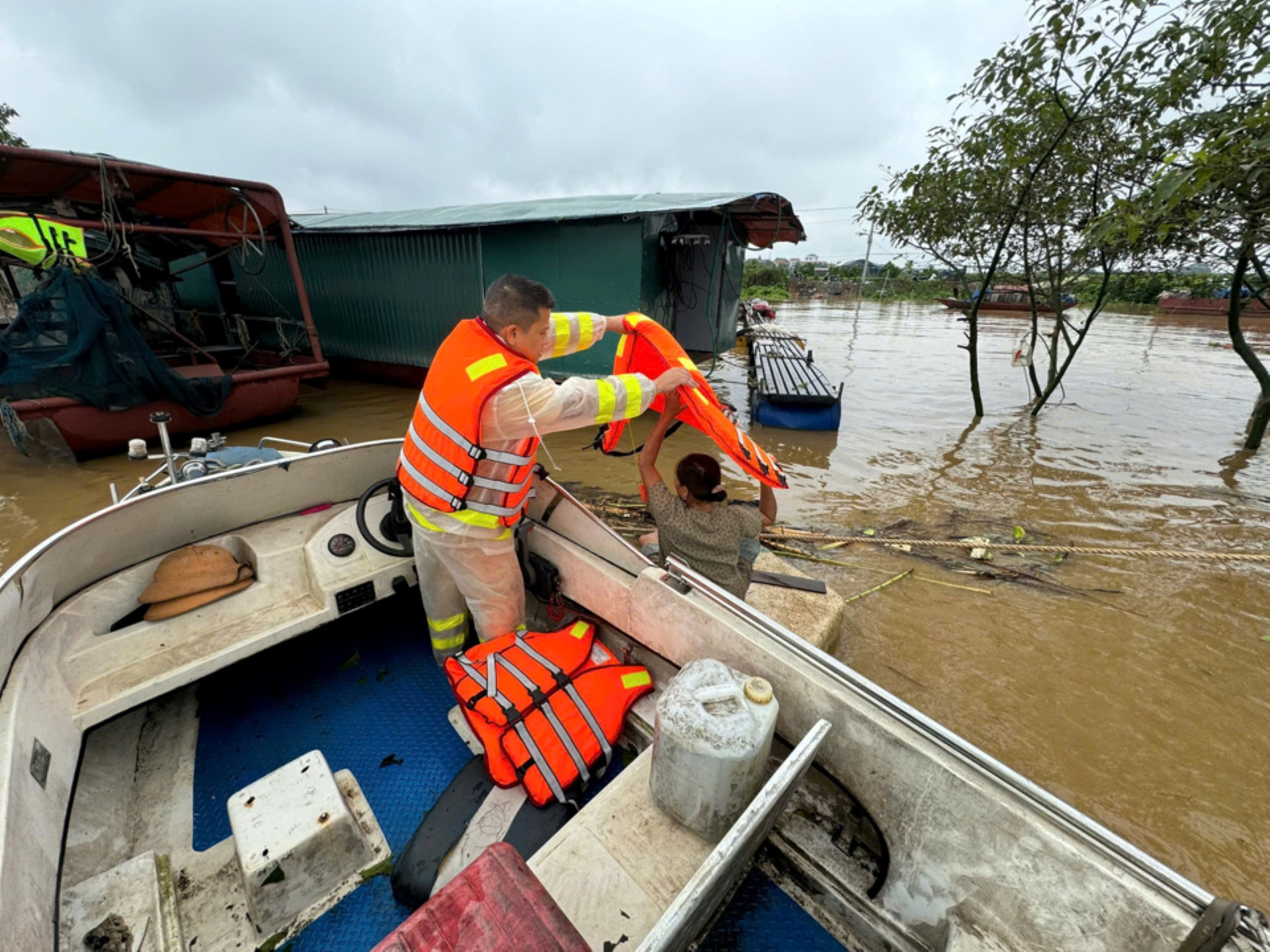 Cảnh sát giao thông đường thủy Hà Nội tuần tra 24/24 giờ để giúp người dân neo buộc tàu, xuồng tại vị trí, phòng chống trôi, lật, thông báo cho dân vạn chài, các tàu xuồng không di chuyển trên các tuyến sông. Trong ảnh, Cảnh sát giao thông đường thủy hỗ trợ người dân di chuyển trên sông, đồng thời tặng áo phao cho nhiều hộ gia đình.