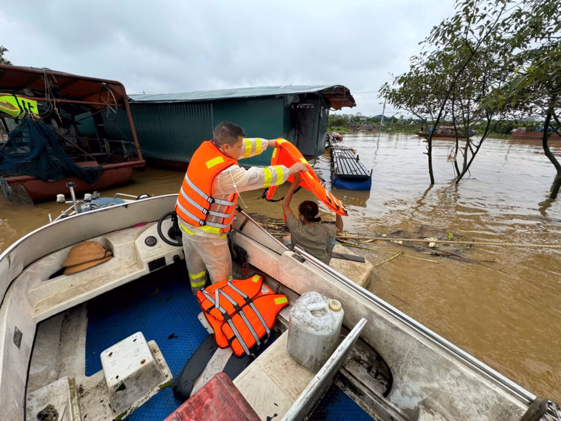 Cảnh sát giao thông đường thủy Hà Nội tuần tra 24/24 giờ để giúp người dân neo buộc tàu, xuồng tại vị trí, phòng chống trôi, lật, thông báo cho dân vạn chài, các tàu xuồng không di chuyển trên các tuyến sông. Trong ảnh, Cảnh sát giao thông đường thủy hỗ trợ người dân di chuyển trên sông, đồng thời tặng áo phao cho nhiều hộ gia đình.