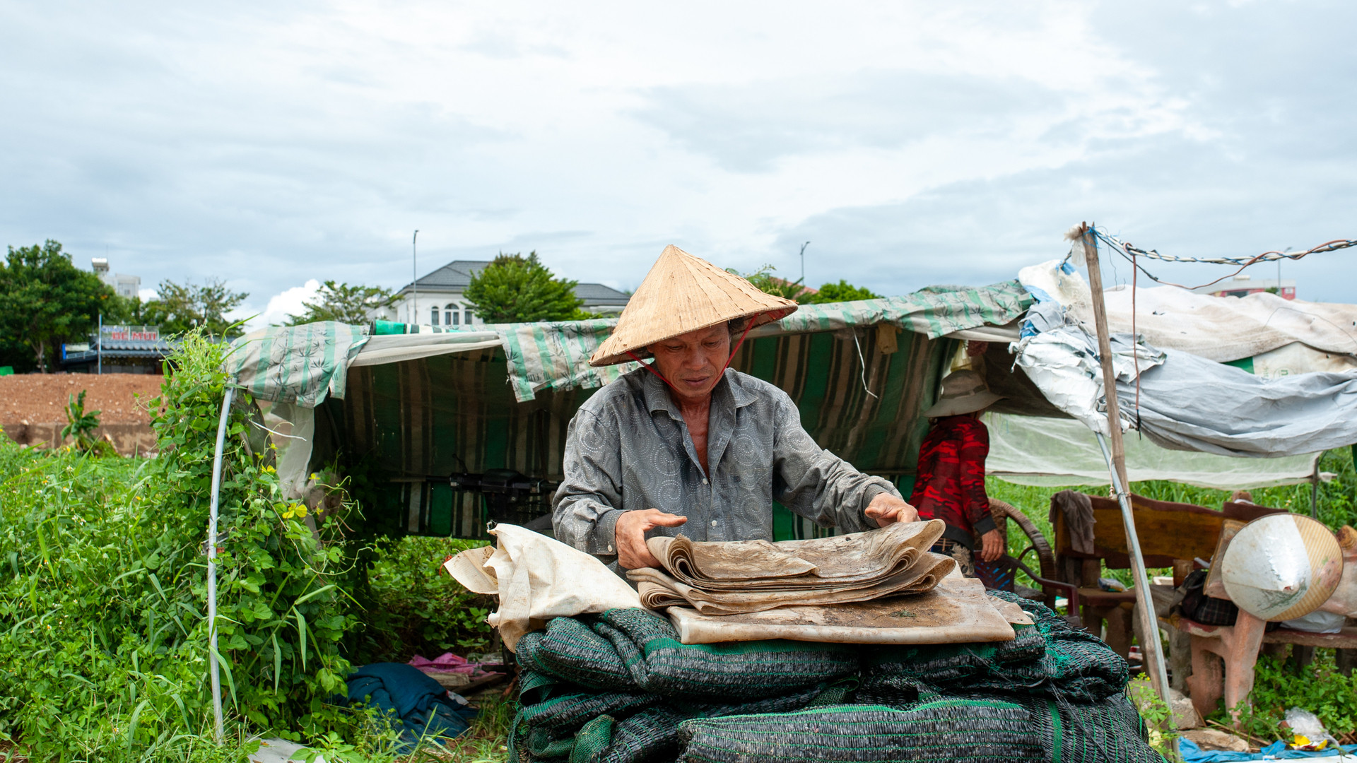 Ông Quân và vợ thu dọn, cất gác đồ đạc để tránh mưa bão.