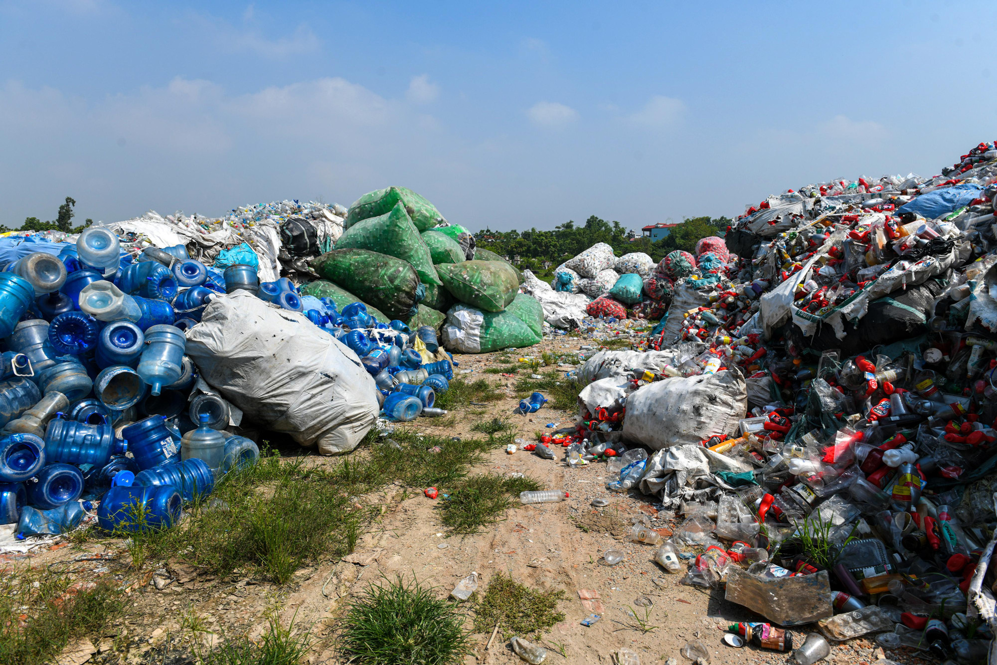 Rác thải nhựa xếp thành những đống lớn dọc các con đường liên thôn. (Ảnh: Thành Đạt)