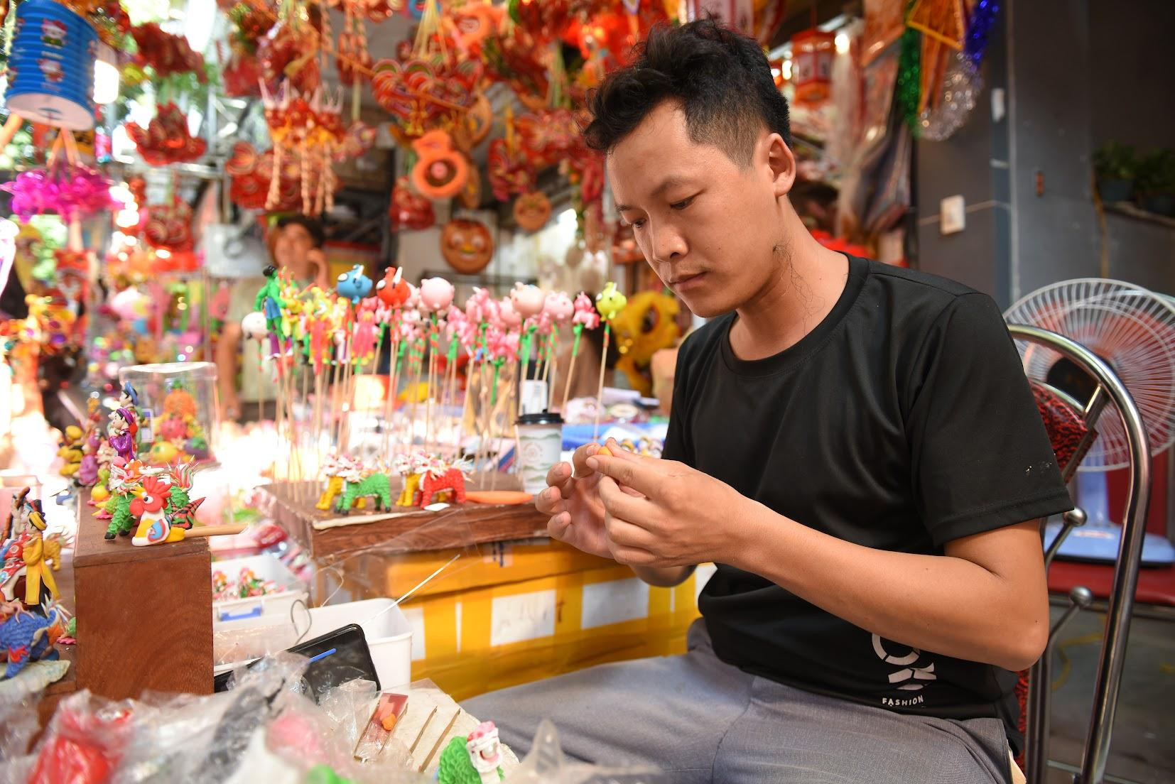 Mỗi dịp Trung thu, nghệ nhân Đặng Văn Hậu lại tỉ mẩn làm tò he trên phố cổ như một cách tôn vinh những mạch nguồn nhân văn ngàn đời của dân tộc. (Ảnh: Thành Đạt)