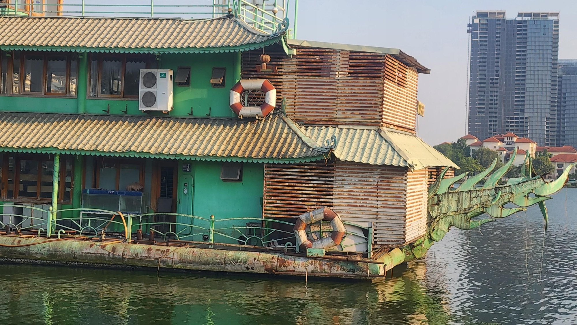 Một du thuyền xuống cấp nằm giữa lòng hồ lặng lẽ.