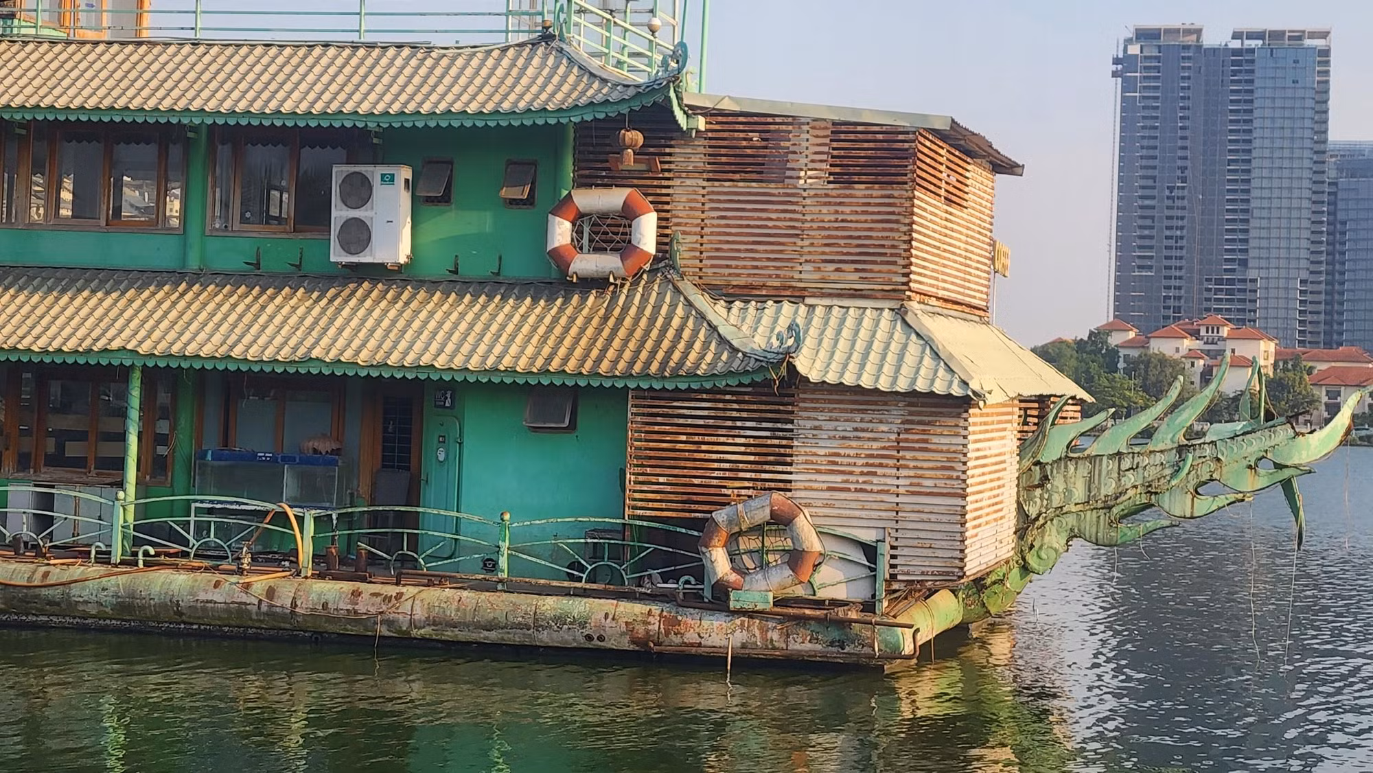 Một du thuyền xuống cấp nằm giữa lòng hồ lặng lẽ.