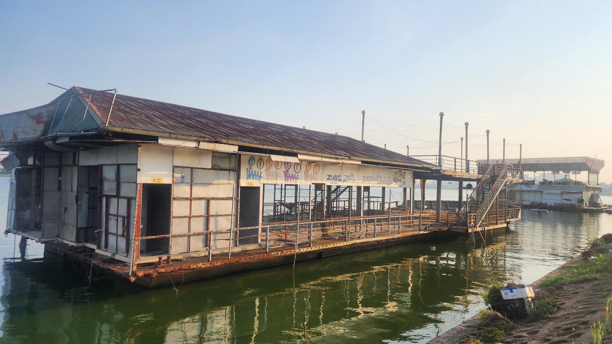 Những hình thù nguệch ngoạc được vẽ trên tấm biển của du thuyền nằm ven bờ đường Nhật Chiêu, trái ngược với quá khứ từng nhộn nhịp khi các du thuyền còn hoạt động.