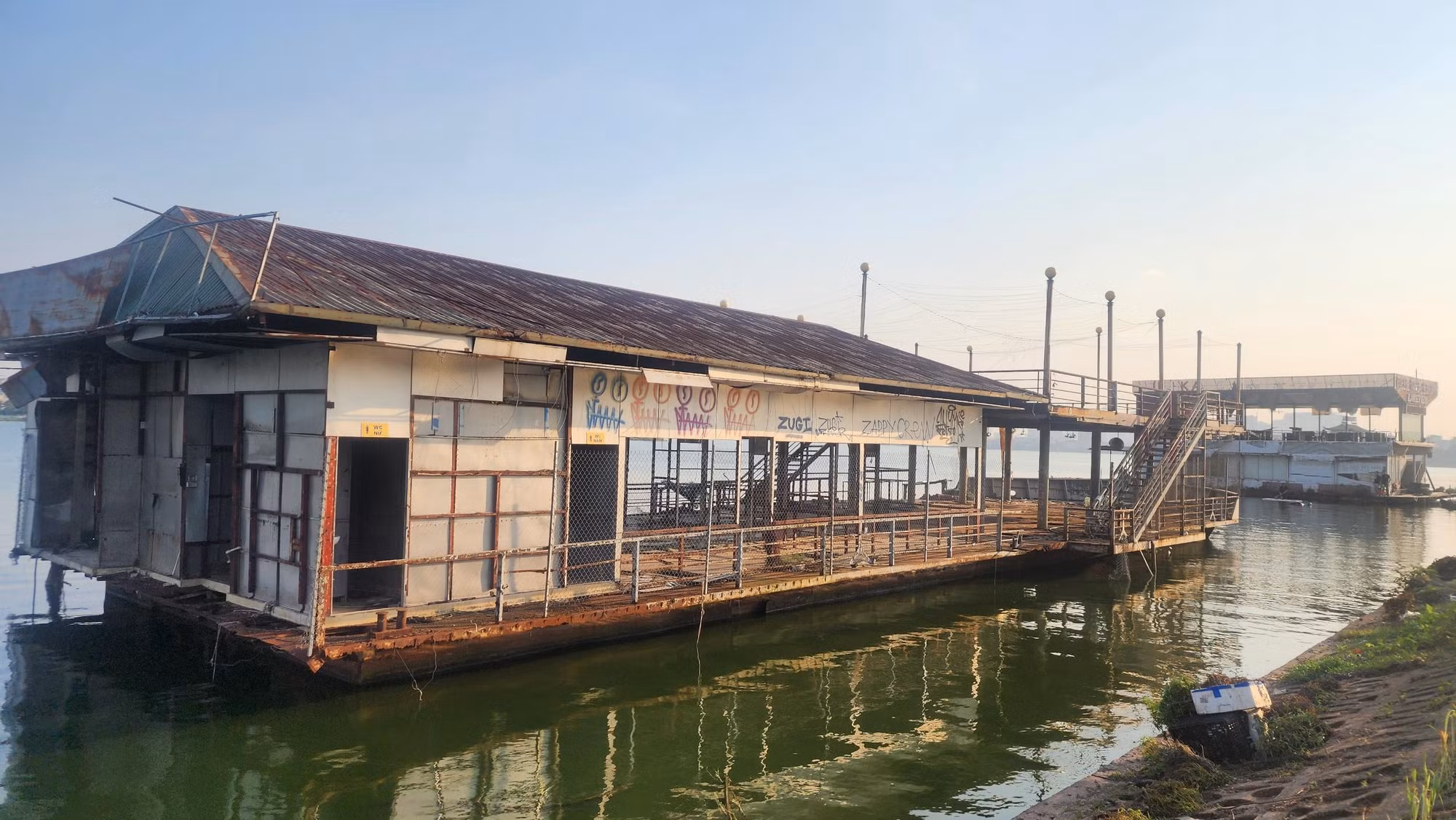 Những hình thù nguệch ngoạc được vẽ trên tấm biển của du thuyền nằm ven bờ đường Nhật Chiêu, trái ngược với quá khứ từng nhộn nhịp khi các du thuyền còn hoạt động.