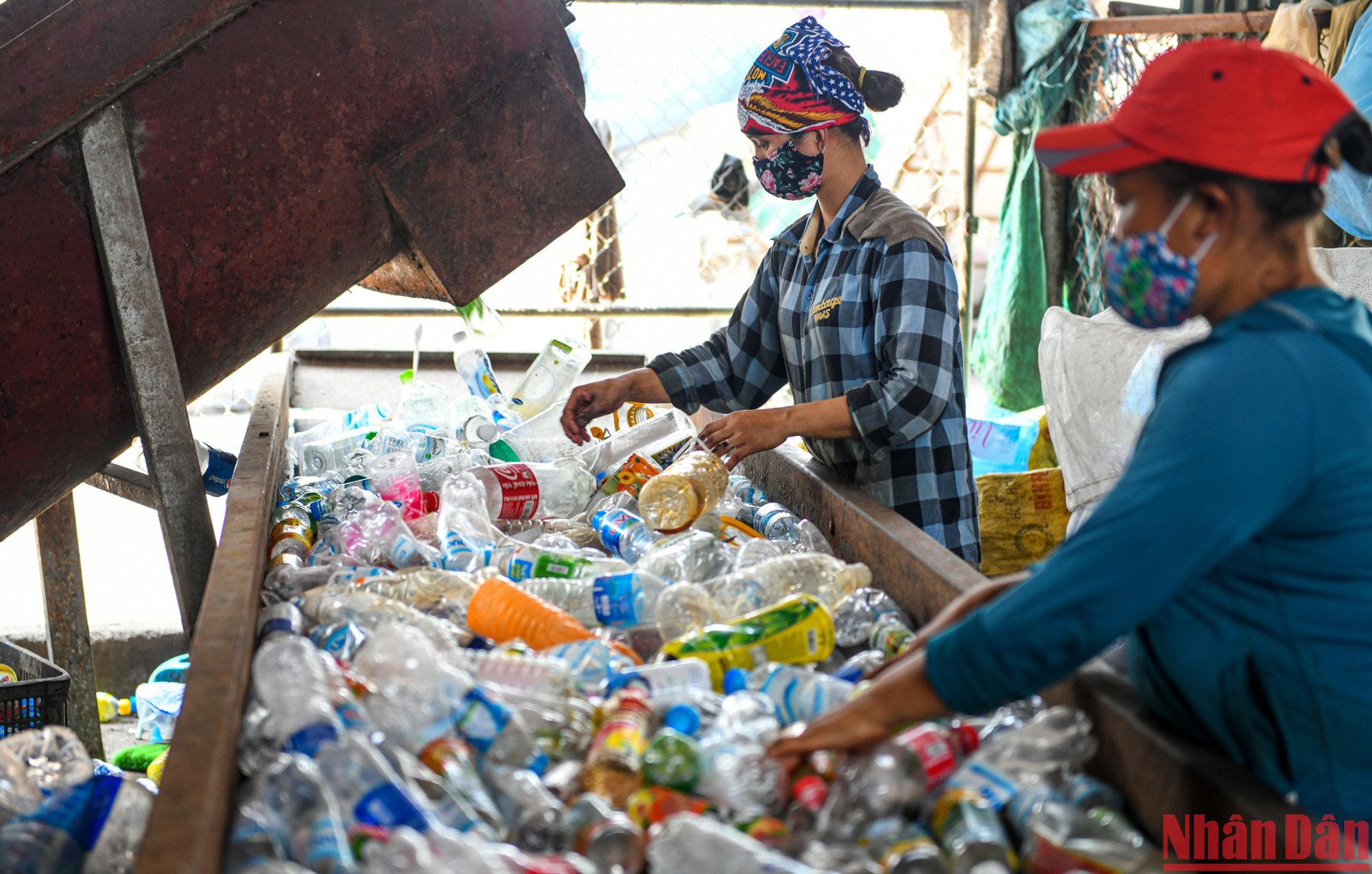 Hai công nhân phân loại chai nhựa trên băng chuyền tại "thủ phủ rác thải nhựa" Xà Cầu. (Ảnh: Thành Đạt)