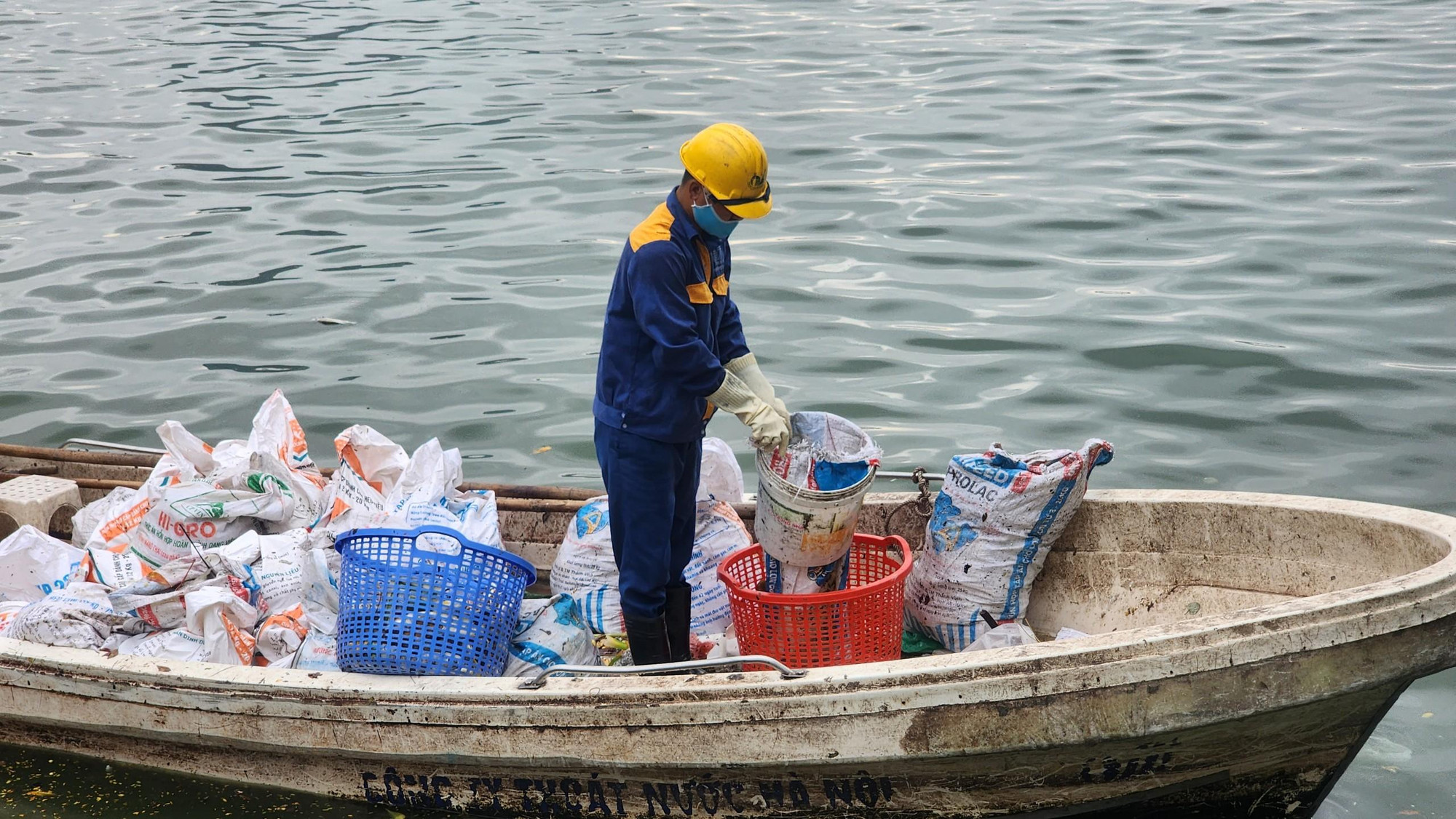 Vớt rác thải cùng cá chết đã trở thành công việc "bất đắc dĩ" thường ngày của các cán bộ, công nhân môi trường trên hồ Tây.