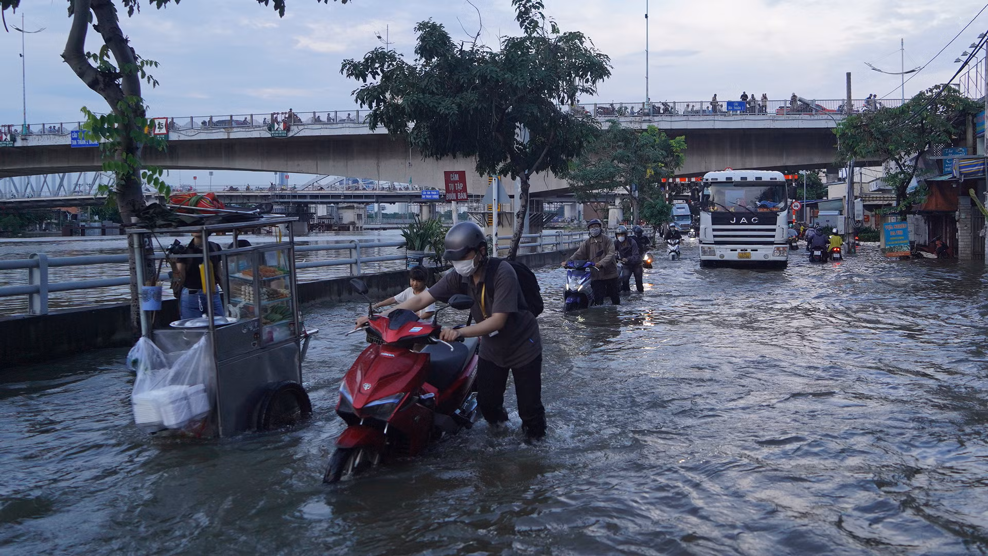 Mặt đường mênh mông nước người dân chật vật đi lại khó khăn.