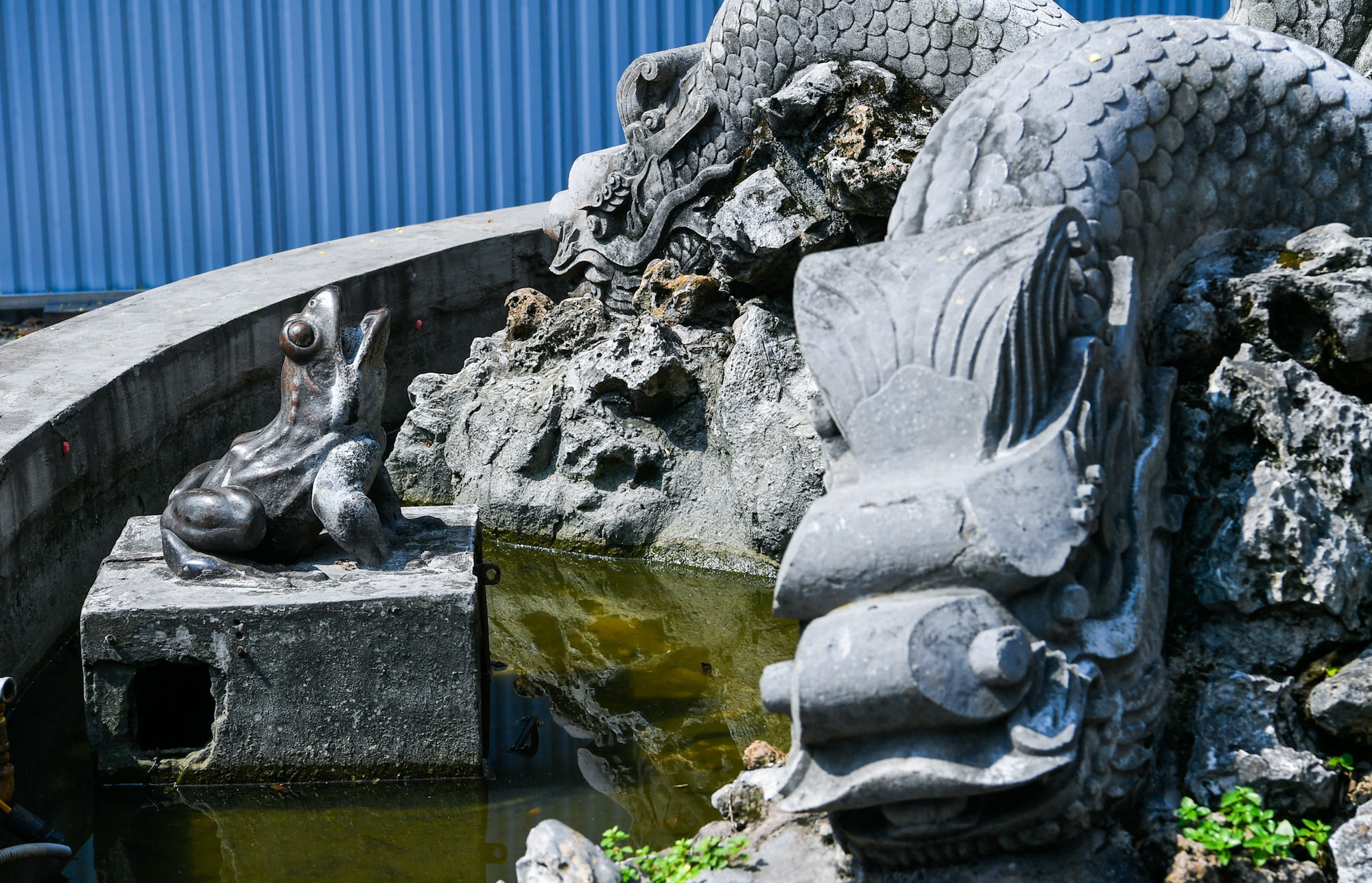 Phía dưới những con rồng đá là những con cóc được đúc bằng đồng, phun nước lên tháp đá nên người Hà Nội thường gọi là vườn hoa Con Cóc