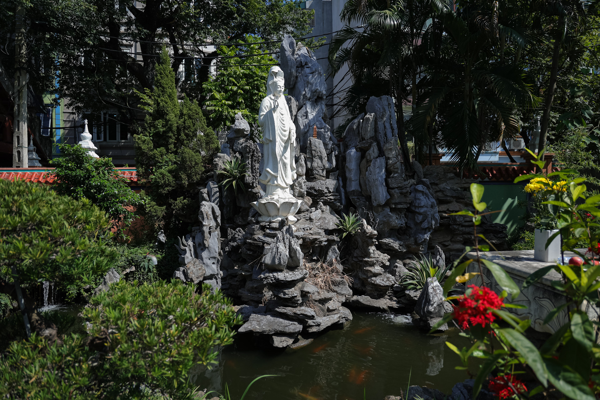 Chùa Long Quang có nhiều tiểu cảnh, đặc biệt ấn tượng với bức tượng Quan Thế Âm Bồ Tát ngự trên bể cá koi. Xung quanh hồ trồng cây xanh và hoa, toả hương thơm dịu mát.