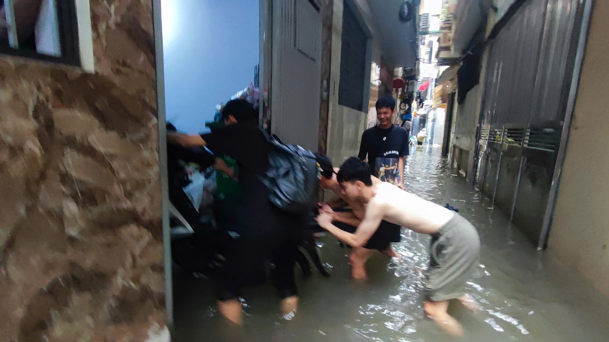 Người dân Tân Triều tranh thủ di chuyển xe máy lên vị trí cao hơn.