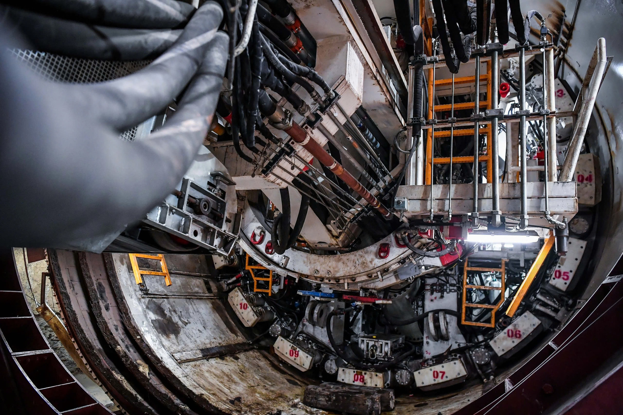 Hiện tại, vị trí mũi khoan TBM Thần tốc đang tiếp cận đã nằm cách vách hầm S9 150m. Máy khoan TBM vận hành theo chu trình khép kín, đào với tốc độ lớn nhất là 60mm/phút, trong quá trình đào máy sẽ phun ra trước đầu cắt hóa chất điều hòa đất hay còn gọi là FOAM giúp làm mềm đất, chống bó và hỗ trợ duy trì cân bằng áp lực đầu gương đào.