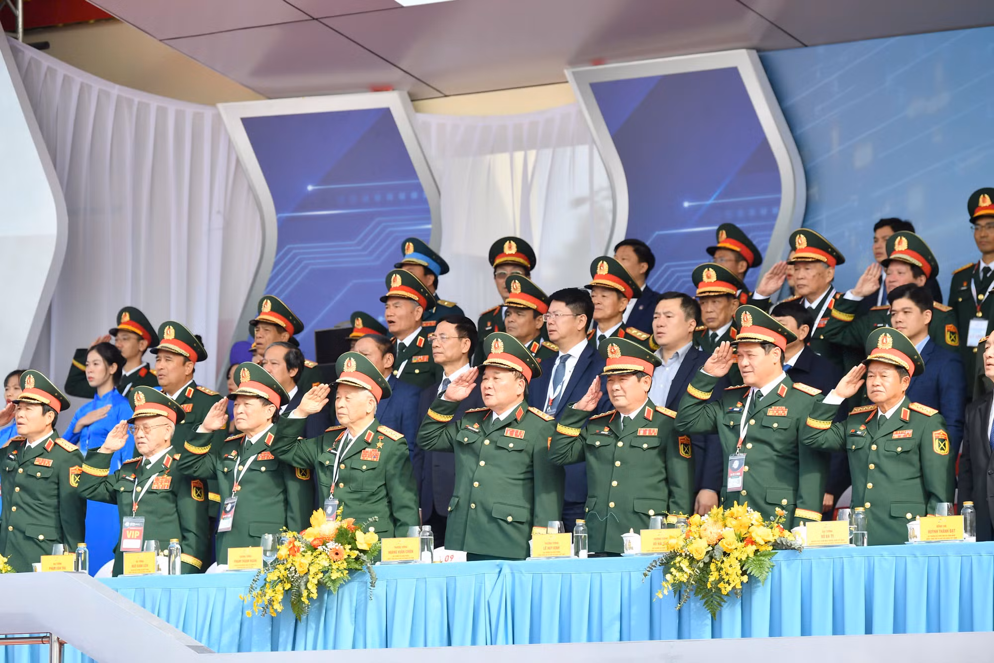 Các đồng chí lãnh đạo Đảng, Nhà nước và các đại biểu thực hiện nghi lễ chào cờ tại Lễ khai mạc.