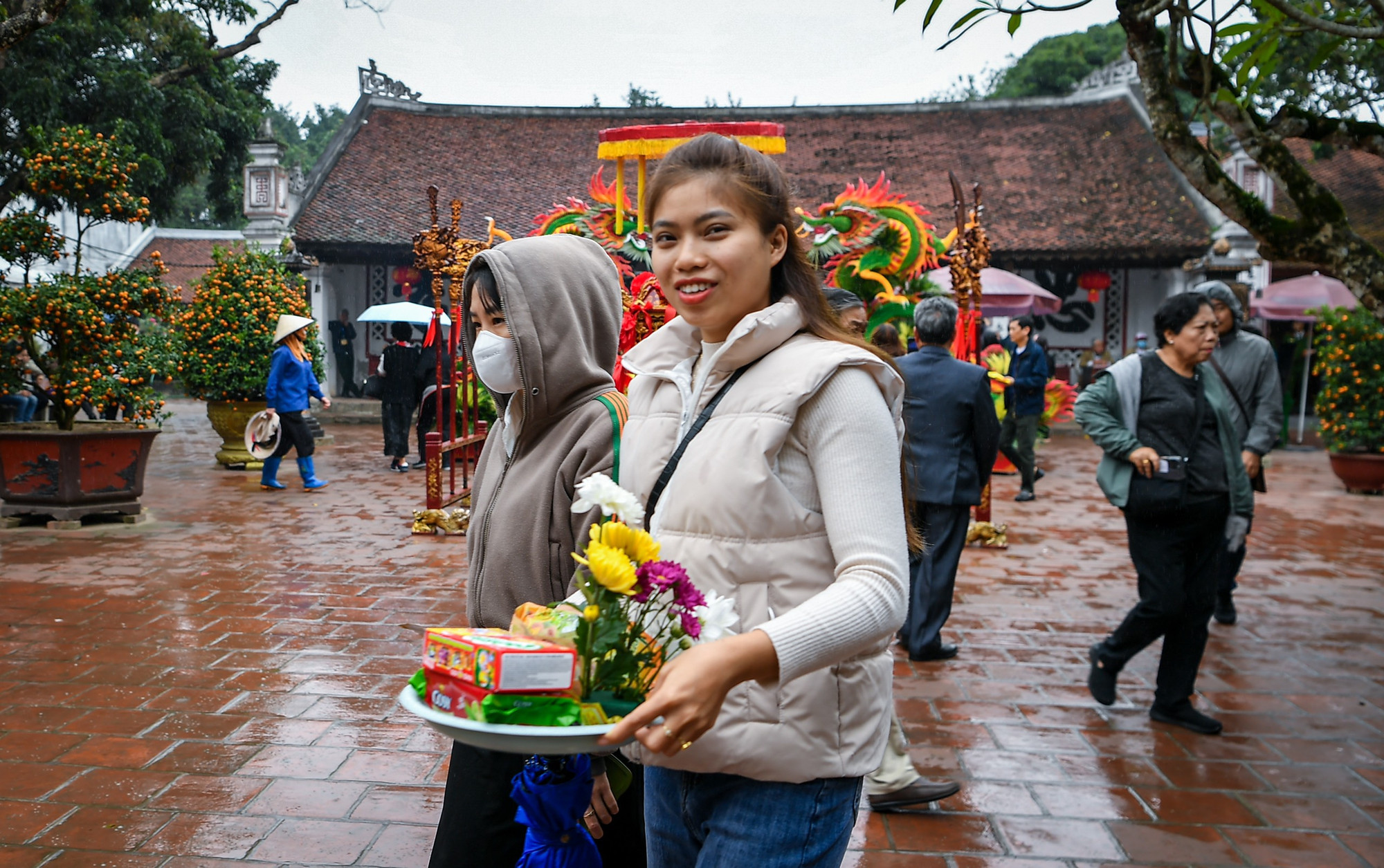 Bất chấp cơn mưa rả rích kéo dài, các du khách vẫn dâng lễ, cầu mong một năm mới nhiều may mắn và tài lộc.