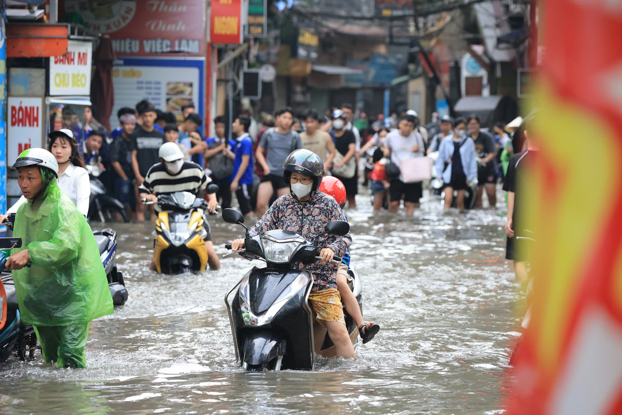 Mưa lớn kéo dài đã khiến cho nhiều tuyến đường ngập nặng. Trong ảnh, người dân di chuyển khó khăn qua ngõ 111 Triều Khúc (Thanh Xuân, Hà Nội)