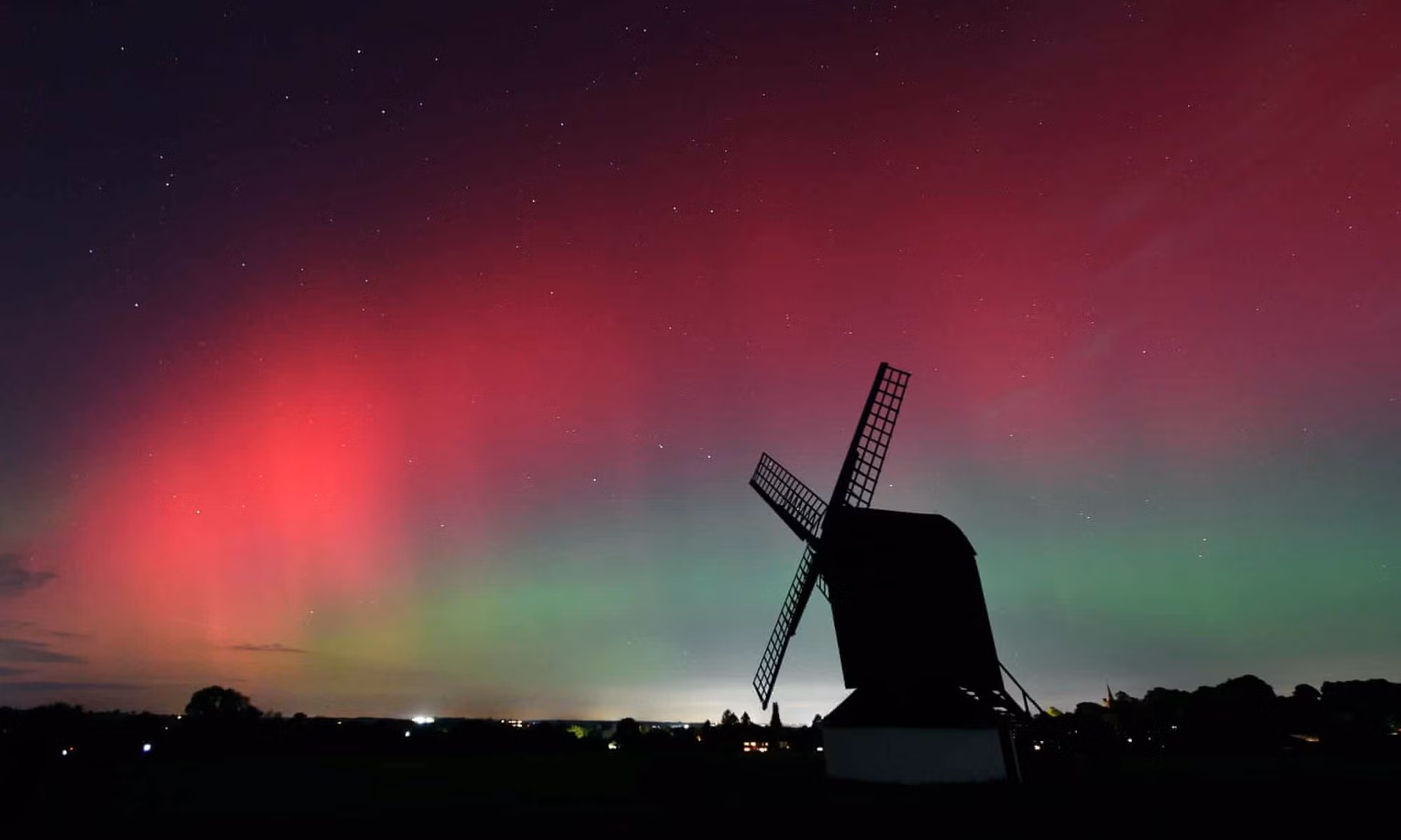 Cực quang xuất hiện phía trên cối xay gió Pitstone ở Buckinghamshire, Vương quốc Anh tối 10/10. (Ảnh: The Guardian)