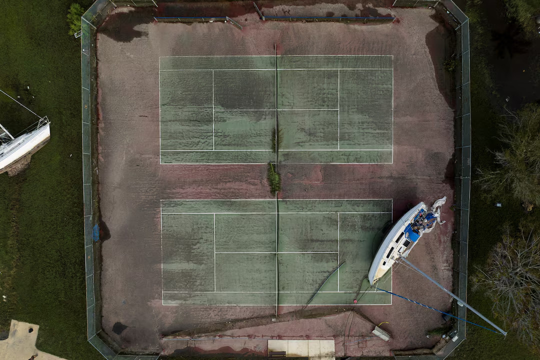 Trong ảnh là một chiếc du thuyền bị mắc kẹt trên sân tennis tại bang Florida sau bão Milton.