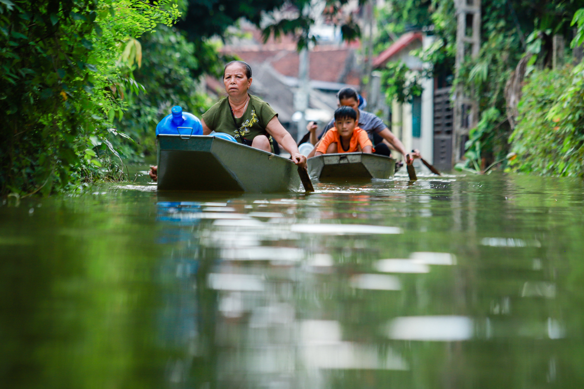 Người dân xã Nam Phương Tiến chèo thuyền đi xin nước sạch về sinh hoạt.