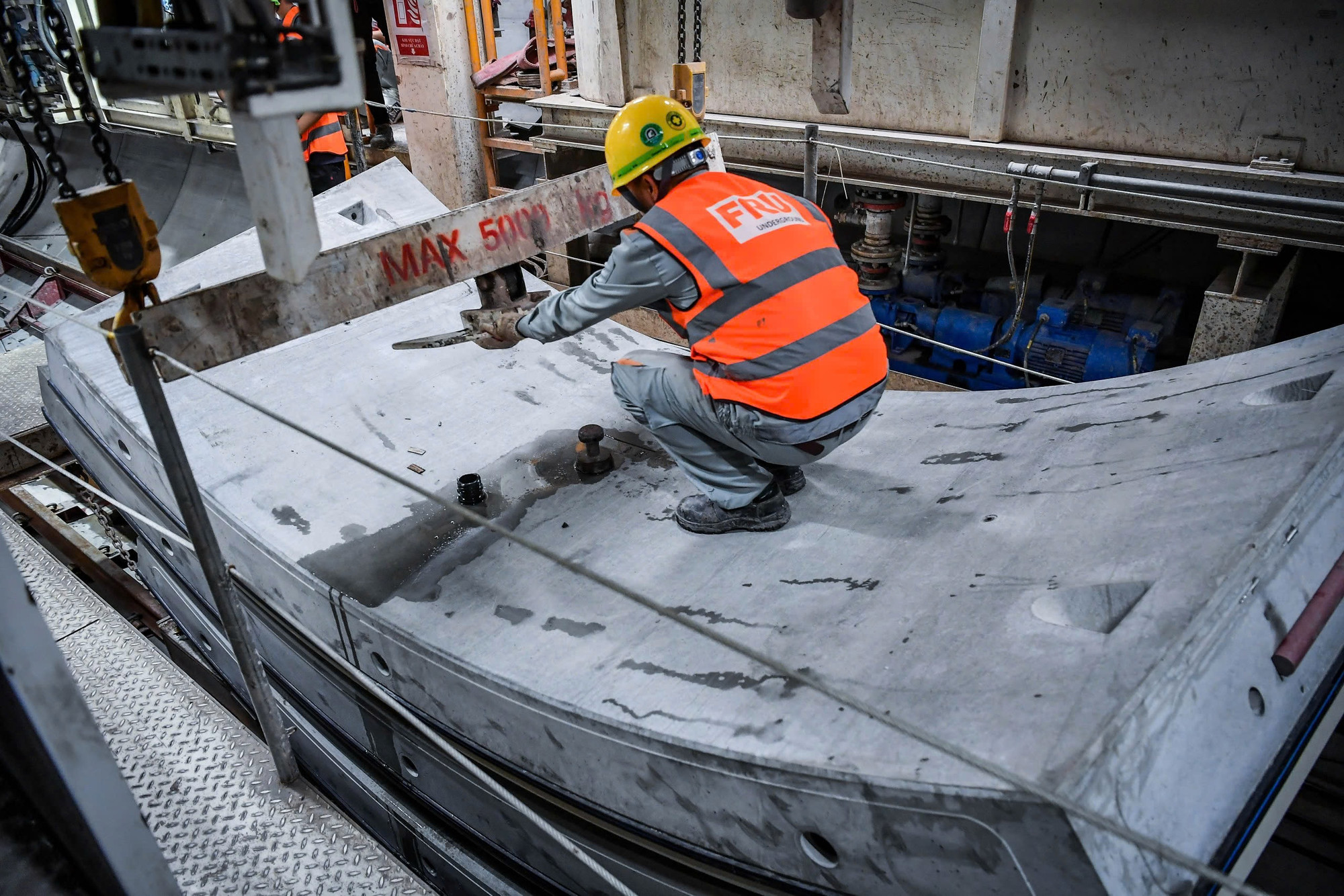 Công nhân tiến hành vận chuyển các tấm vách hầm bằng tay robot.