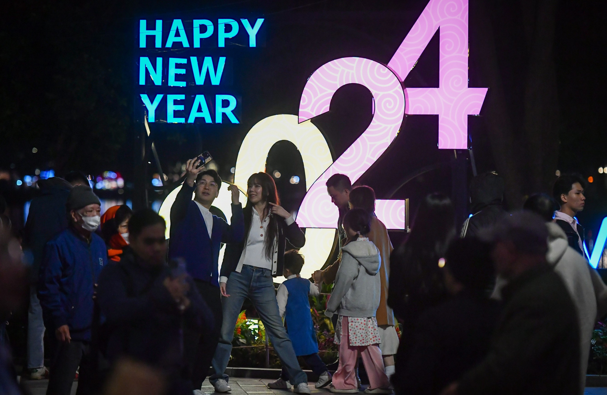 Đôi bạn trẻ ghi lại kỷ niệm trước tấm biển chào mừng năm mới được dựng bên hồ. Đôi bạn trẻ ghi lại kỷ niệm trước tấm biển chào mừng năm mới được dựng bên hồ.