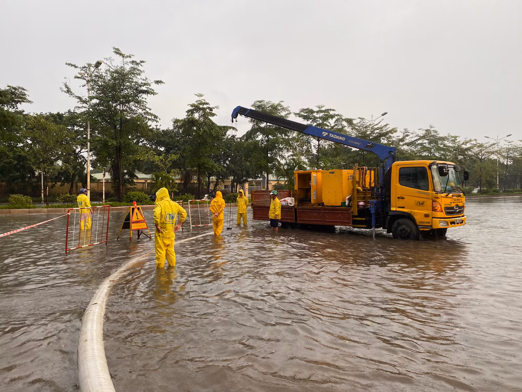 Công nhân công ty Thoát nước Hà Nội ứng trực tại điểm ngập trên phố Đàm Quang Trung.