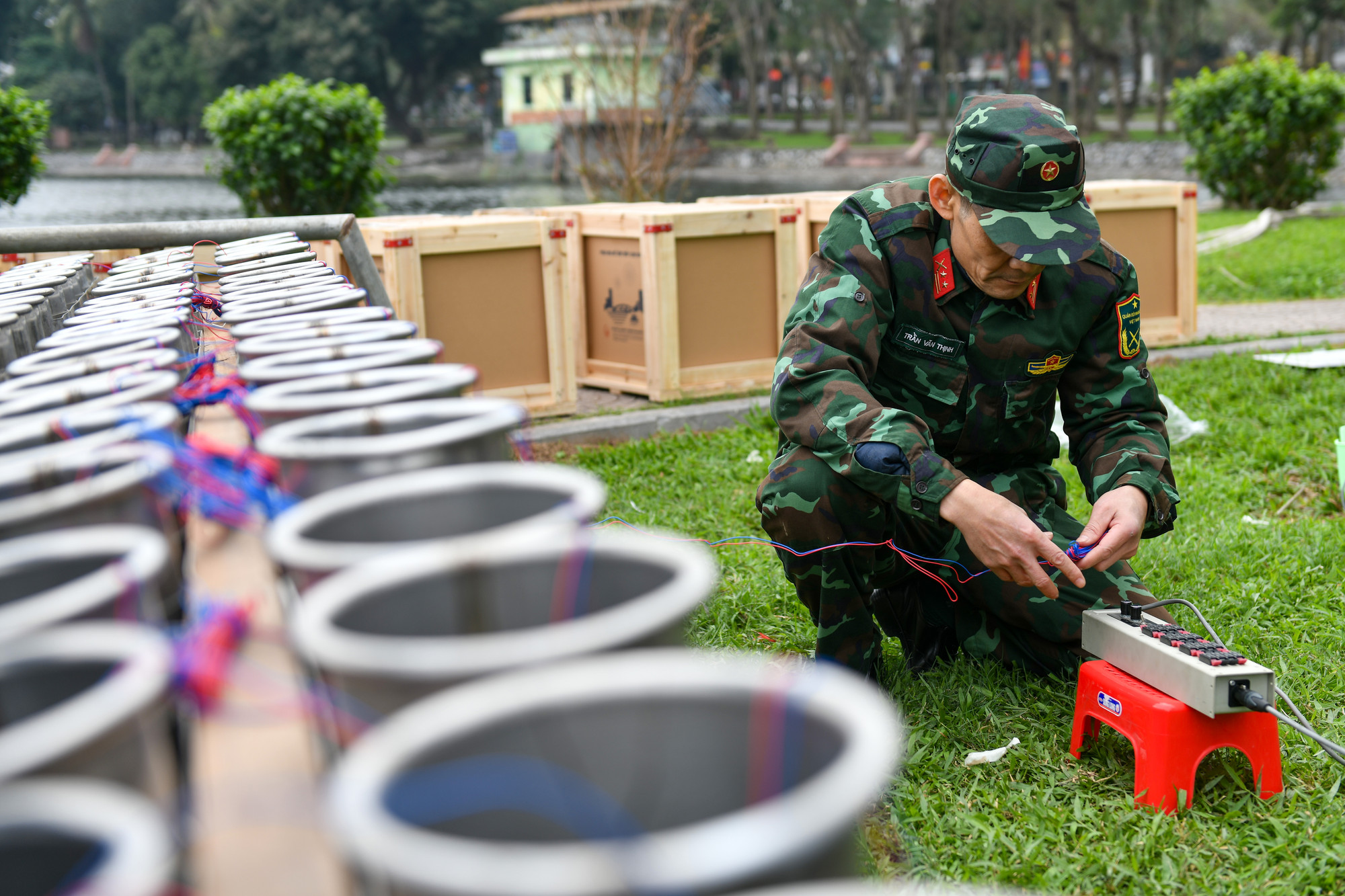 Thao tác nối dây mồi lửa điện từ các quả pháo hoa vào hộp cầu đấu sau khi cố định các ống phóng pháo hoa bằng gông sắt và dây dù.