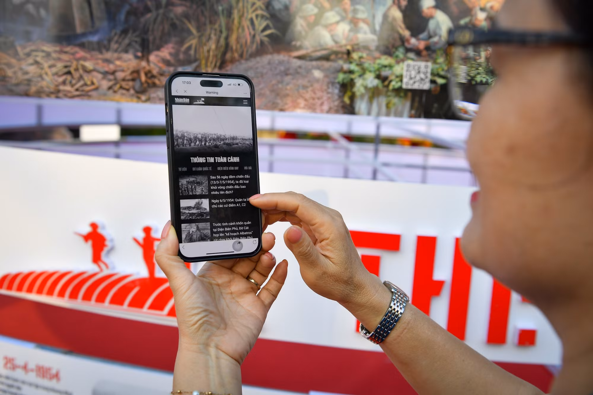 Một du khách thích thú với chuyên trang đặc biệt Chiến thắng Điện Biên Phủ của Báo Nhân Dân.