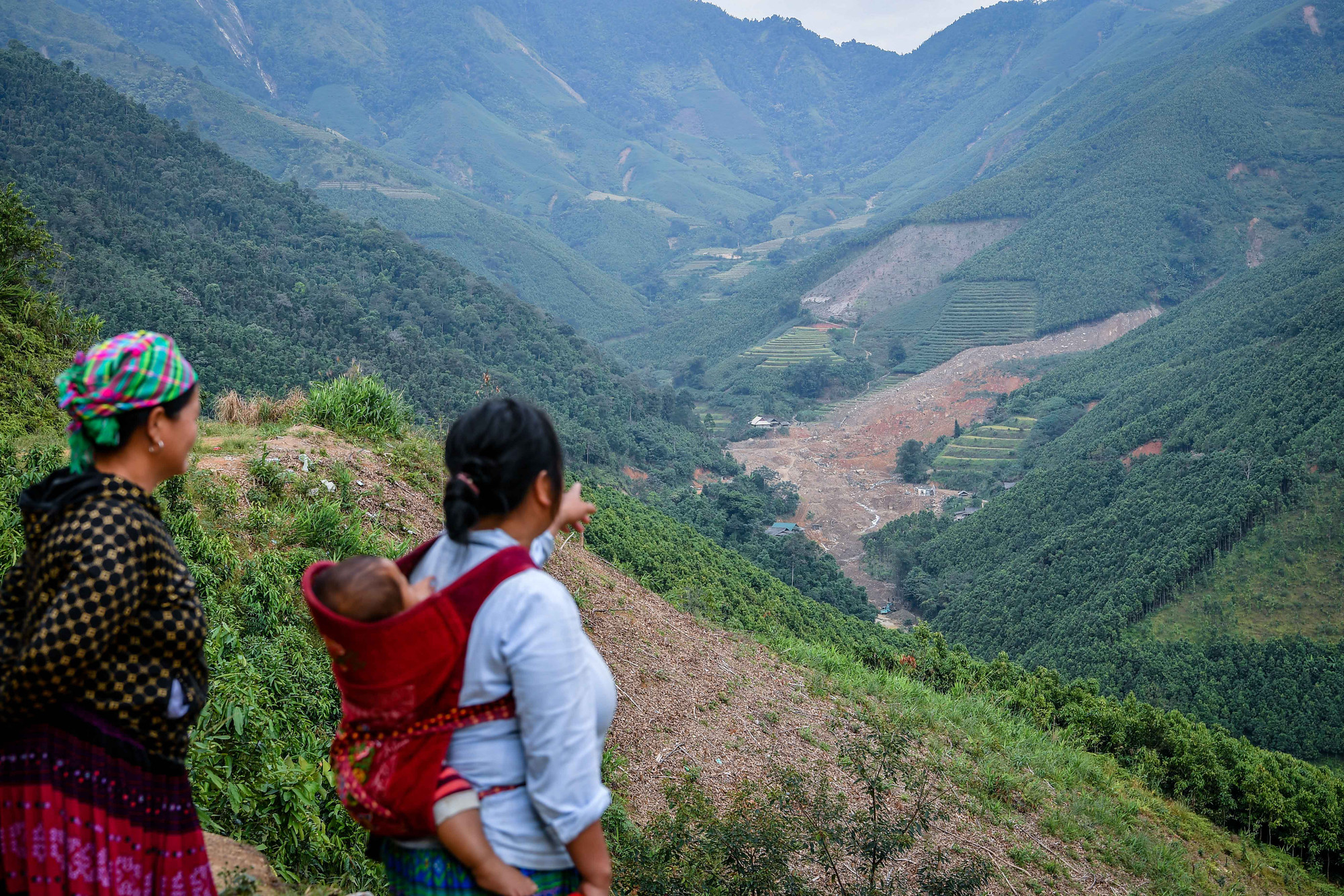 Chiều chiều, những phụ nữ người Mông bản Nậm Tông vẫn địu con, đứng trên triền dốc nhìn về ngôi làng cũ chỉ còn ngổn ngang những vệt bùn đất...